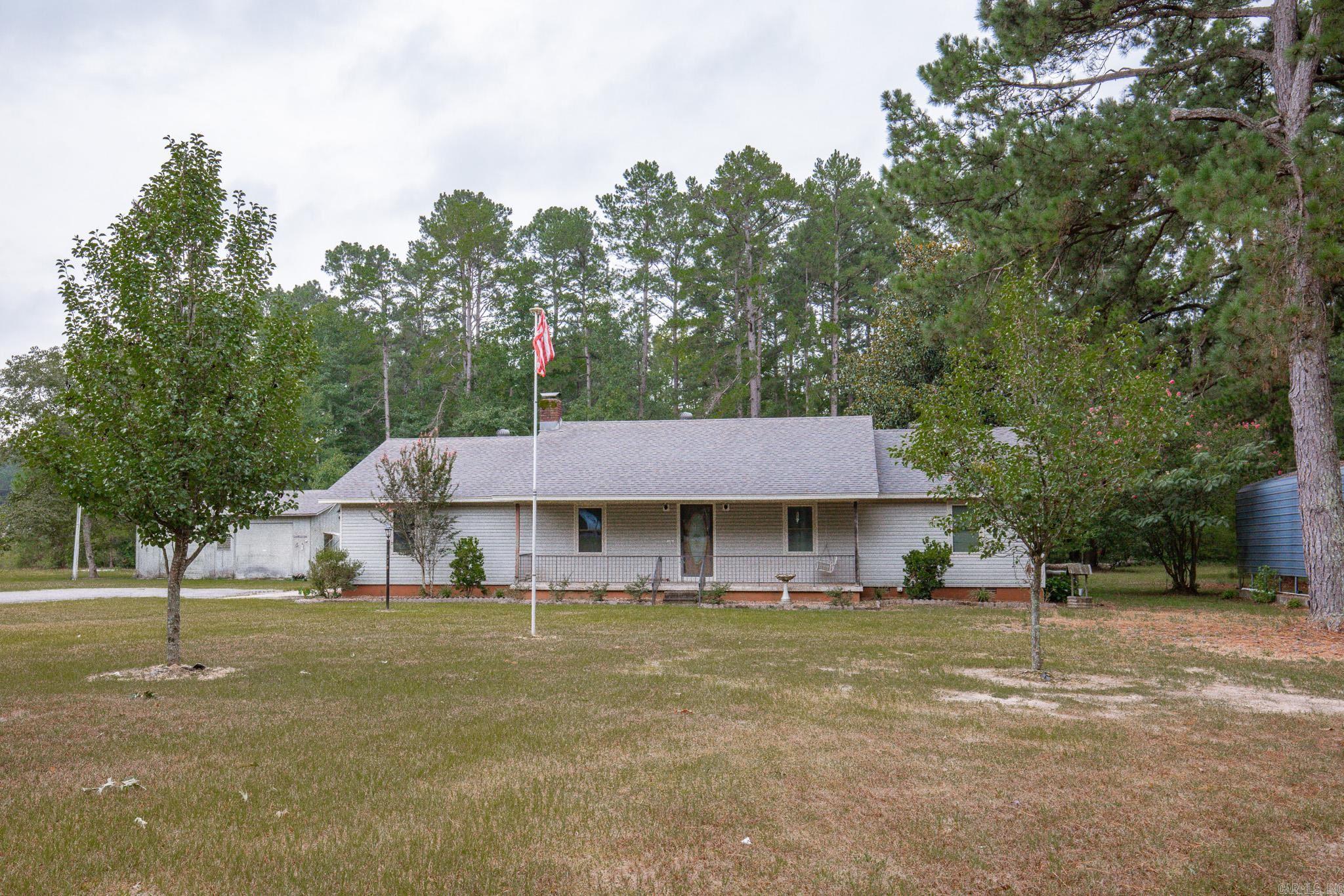 Tucked away on a peaceful 1.4 acre lot, this home offers the perfect blend of rustic charm and updated convenience. Built in 1989, this cozy retreat has been thoughtfully updated with country touches that make it warm and inviting. Step inside to find a spacious living room with vaulted ceiling, dining space with lots of natural lighting and a kitchen with gas stove & updated cabinet doors. Off of the kitchen there is a nice size laundry room and an additional space that could be used as a workshop/craft room that leads out to the back patio. There is a generac gas generator, gas water heater, gas heat. Appliances including washer and dryer convey with acceptable offer. New vinyl plank flooring in hall and a bedroom. Primary bedroom includes en suite bath with double vanity and walk in shower. Outside, enjoy morning coffee on the covered back porch with a fenced in area that is perfect for pets. This property also includes a shop with lean to and a camper shed- perfect for storage or tinkering. The roof on the home is just 2-3 years old, providing peace of mind.