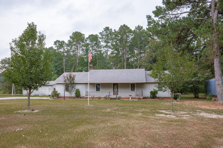 Tucked away on a peaceful 1.4 acre lot, this home offers the perfect blend of rustic charm and updated convenience. Built in 1989, this cozy retreat has been thoughtfully updated with country touches that make it warm and inviting.  Step inside to find a spacious living room with vaulted ceiling, dining space with lots of natural lighting and a kitchen with gas stove & updated cabinet doors.  Off of the kitchen there is a nice size laundry room and an additional space that could be used as a workshop/craft room that leads out to the back patio. There is a generac gas generator, gas water heater, gas heat. Appliances including washer and dryer convey with acceptable offer. New vinyl plank flooring in hall and a bedroom. Primary bedroom includes en suite bath with double vanity and walk in shower.  Outside, enjoy morning coffee on the covered back porch with a fenced in area that is perfect for pets.  This property also includes a shop with lean to and a camper shed- perfect for storage or tinkering.  The roof on the home is just 2-3 years old, providing peace of mind.