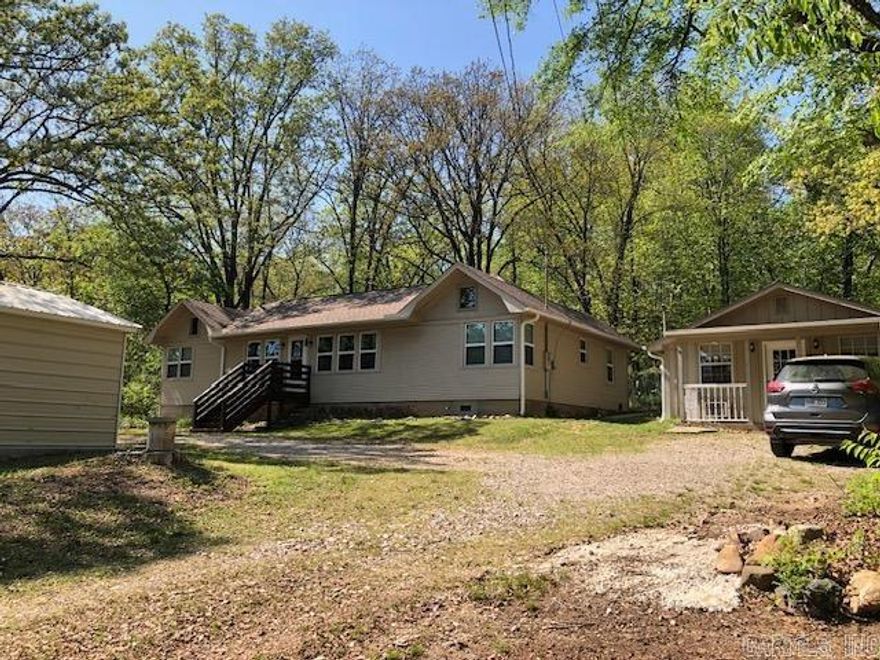 What a great opportunity to purchase two homes selling as a package.  The main house has 3 bedrooms and 2 full baths and an amazingly large main living area. Its open and inviting gathering space has vaulted ceiling and decorator nooks.  And  you get an additional sweet 1 bedroom, 1 bath guest cottage next door with generous amount of living space.  Great set up for those needing additional living quarters full time or for monthly rental income. Conveniently located just minutes from major shopping, medical facilities, bypass and Oaklawn.  It has a fenced in backyard with a delightful flagstone sitting area where you can relax and enjoy the privacy of the expansive wooded hillside.  Watch the deer and listen to the birds with your coffee.   Current owner has done numerous improvements and upgrades: windows, roof, gutters, main water lines with a new double garage and detached storage building being the most recent. Seller holds inactive Arkansas Real Estate License