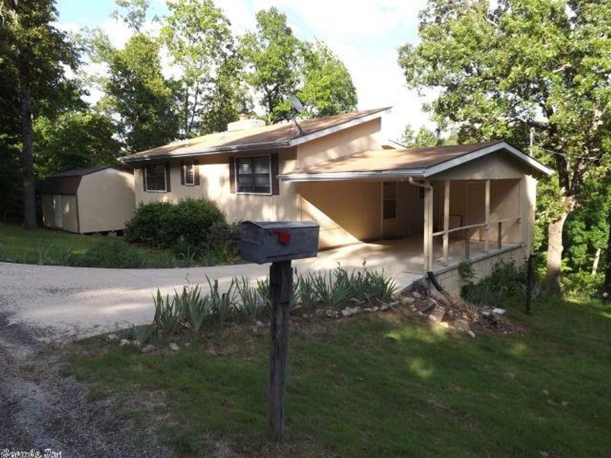 Uniquely built split-level home surrounded by large trees with privacy in mind. This home offers secluded quiet beauty with large living/dining room, vaulted ceilings, stone fireplace with insert, kitchen, utility area and deck on main level. Up are the full bath & both bedrooms with clerestory windows for light, ventilation & passive solar in the winter. A spiral staircase leads down to a family room, and interior workshop. Covered decks and terraced garden area on the sloped backyard perfect for preppers.