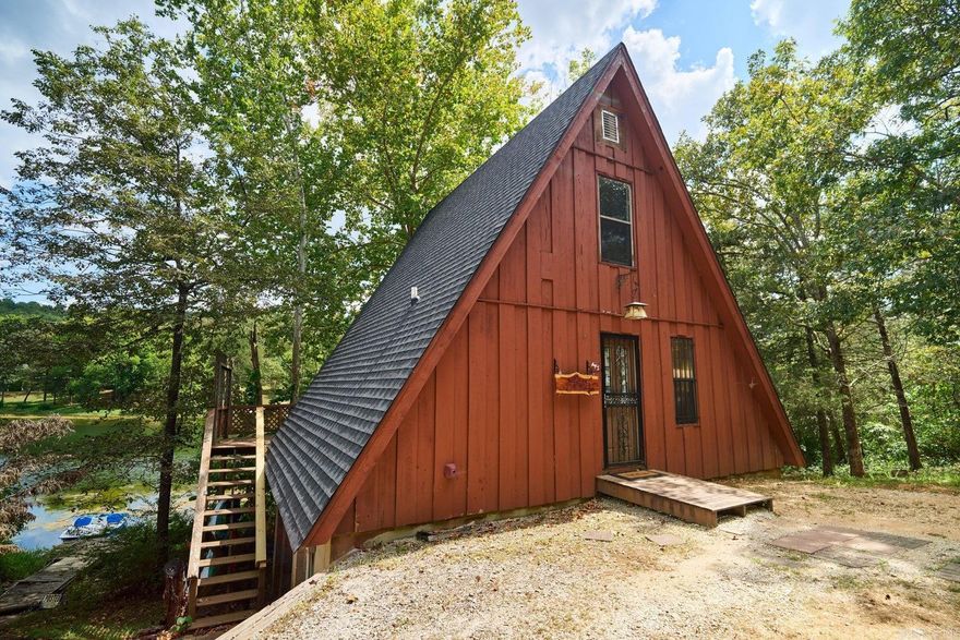 Tucked away on a shady, wooded lot, this charming A-frame cabin offers the perfect lakeside retreat. Fully furnished and thoughtfully updated, the 1-bedroom, 1-bath home blends rustic character with modern comfort. Inside, vaulted wood ceilings and warm wood floors create an inviting, open feel, while the updated kitchen features granite countertops Step outside to the lakeside deck and take in peaceful water views surrounded by nature, or head down to your private dock for swimming, fishing, or sunset evenings on the lake. Whether you're looking for a weekend escape, vacation rental, or cozy year-round getaway, this turnkey cabin delivers serene lake living at its best. Currently being used as an AirBnB.