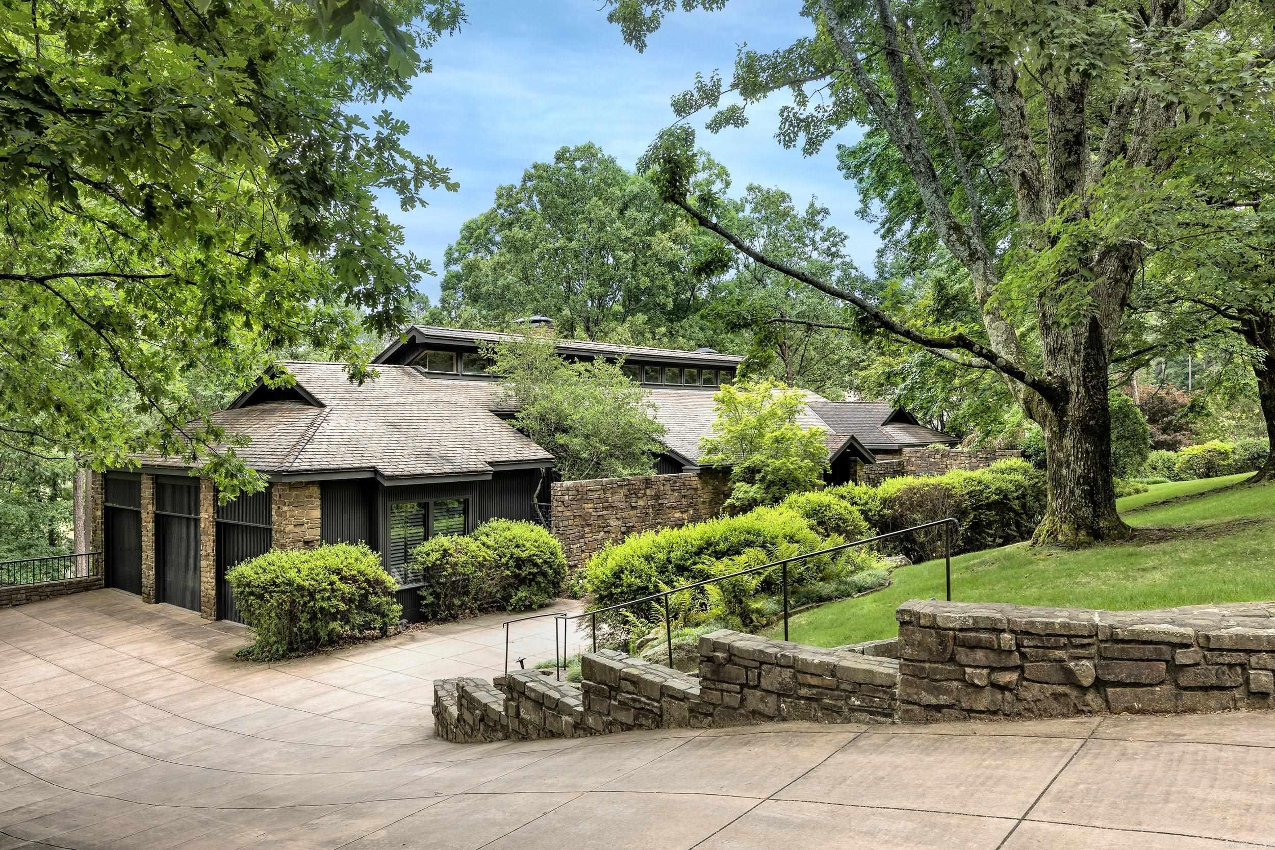 This is a unique opportunity to own a custom-built contemporary masterpiece by Jack Hartsell. Boasting 4 BR and 3.5 BA, this stunning residence seamlessly blends natural elements with sophisticated design to create a serene oasis like no other. As you step inside, you are greeted by soaring vaulted wood ceilings that create an open and inviting ambiance throughout the home. The Ozark stone work accents the newly installed pristine hardwood floors add an elegant touch to the interiors, the freshly painted walls exude a sense of freshness and modernity. Perched on a generous 1.03 acre lot, this residence offers million-dollar views of the surrounding landscape and enchanting gardens that enhance the overall appeal of the estate. Taking in the borrowed view of the lush greenery and pond on the golf course, the outdoor space is a true retreat. The primary suite is a sanctuary in itself, featuring a vaulted ceiling, a cozy sitting area with a fireplace and a dedicated office space. No detail has been spared in this home, with a complete remodel of 2 bathrooms. The oversized 3 car garage, second living retreat downstairs with fireplace and so much more! This is a MUST SEE!