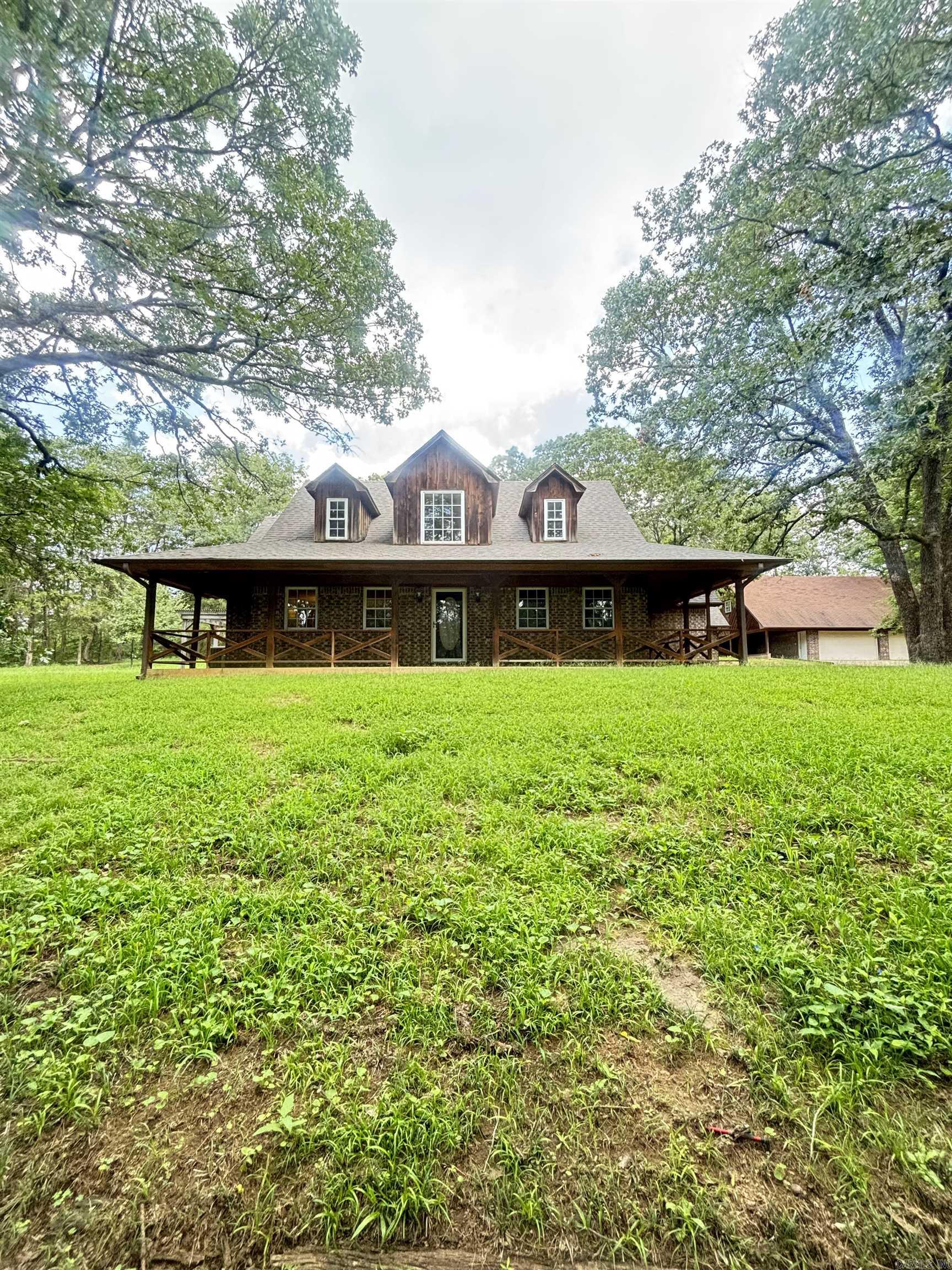Discover the perfect blend of comfort and nature! Short drive to Lake Dardanelle. This 2-story home on 4 acres features 3 bedrooms, 3 bathrooms, gorgeous main living area with vaulted ceilings and custom wood walls, and a bonus room with woodburning stove. Enjoy picturesque views from the large windows in living room that give the space an open, airy feel. Property boasts a small pond, covered deck, and separate apartment complete with bathroom above the detached 4-car garage. There is also a 2-car garage attached. Home has been given a facelift with new carpeting, roof, and some repairs to subfloor, wiring, plumbing and bathroom vents. Don't miss your chance to own this idyllic sanctuary - schedule a showing today!