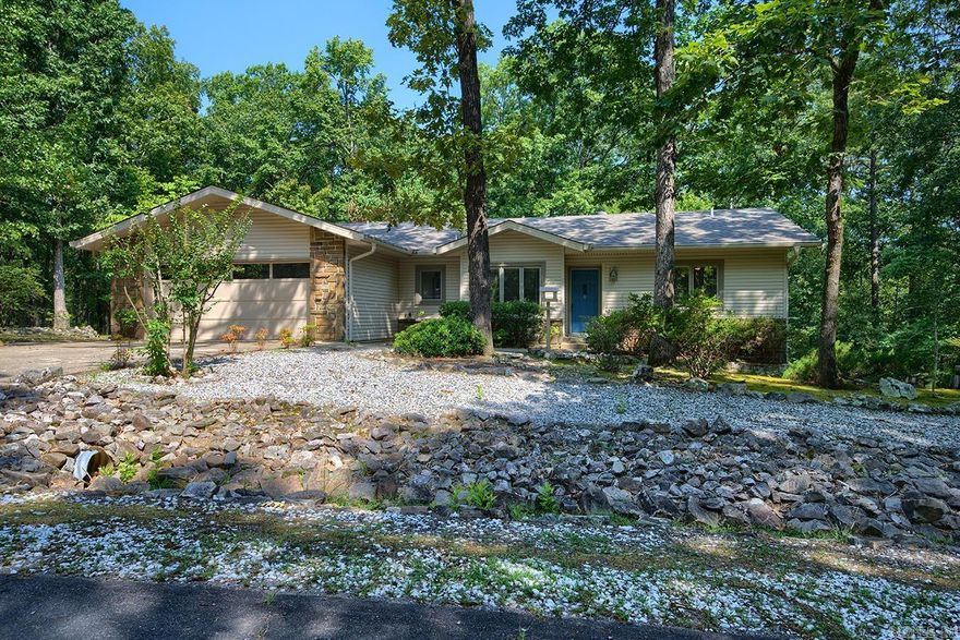 This bright, peaceful well-maintained home with its serene park-like back yard and desirable floor plan exudes relaxation  both indoors and out. Step inside and your eyes are immediately drawn to the vaulted ceiling in the great room, into the open sunroom with its wall of windows, and out to the expansive wooded back yard. Features include updated bathrooms, split bedroom floor plan, skylights, spacious eat-in kitchen, cozy fireplace, large 2 car garage, workshop,  and extra storage space. Located just minutes from beautiful Lake DeSoto, Waypoint Marina & Cafe, hiking trails, miniature golf, restaurants, DeSoto Golf Course, Clubhouse, and outdoor swimming pool. Enjoy nature at its finest and your coffee every morning in the peaceful sunroom or on the deck of this tranquil residence situated between a vacant lot and common property! (Be sure to View the virtual tour.)