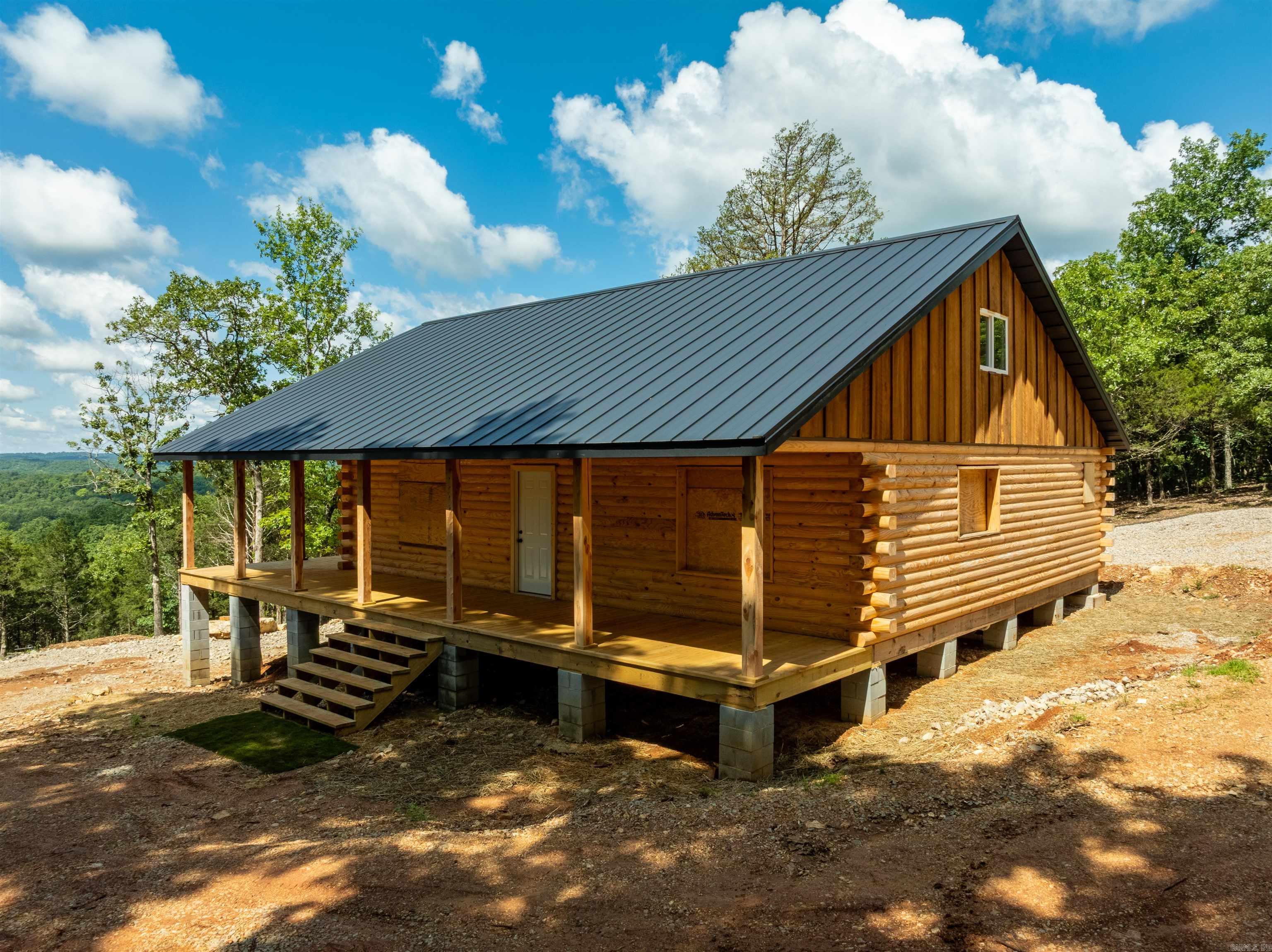 Ozark Dream Cabin ā New Log Home on 6+/- Acres waiting on you to finish with your style and with Gorgeous Views, a wet weather Stream & Cherokee Village Access Perched atop Whitehorse Mountain in Sharp County, AR, this nearly complete with 8ā logs, this cabin offers 6+/- private acres with stunning views, a seasonal stream, and waterfall. The 1,440 sq ft (1,216 main + 224 loft) cabin includes 2 bedrooms, 3 baths, Amish-built trusses, a standing seam metal roof, wraparound porches, and a wheelchair-friendly main floor. Septic, electric (Entergy), plumbing rough-in, and water (Cherokee Village) are already in place. Wired for mini split, plumbed for gas. All was done by professionals. Camper hookup and dual driveways included, one off paved road and one off gravel. BONUS: A .29+/- acre lot in Cherokee Village provides full access to 7 lakes, 2 golf courses, rec centers, trails, and more! Minutes to town amenities. Finish the interior your way and enjoy peaceful Ozark living with modern perks.