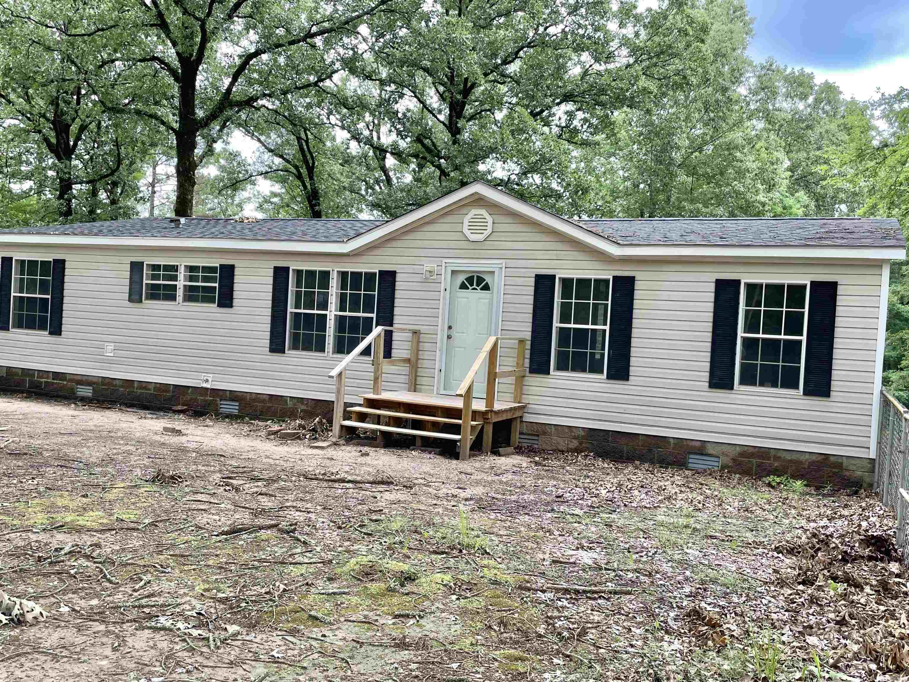 A very nice doublewide mobile home on a permanent foundation. New porch and steps both front and back. New interior paint throughout, all new kitchen appliances, new flooring, new toilets. Roof replaced in 2024 and a new compressor in 2024. A very spacious living area, vaulted ceiling, spacious laundry room. The drive is concrete and leads to an exterior entry door. Trees around the home have all been trimmed. A storm shelter as well as a small storage building are also on the property. A must see, call today to schedule a showing.
