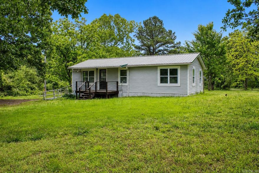 Tucked well back off the road, this cute updated home offers the peaceful country setting so many buyers are searching for. Sitting on approximately 2 +/- acres after the front .93 +/- acres of highway frontage is surveyed prior to closing, this property has the makings of a great little homestead or farmstead. The site-built home offers a comfortable layout with 3 bedrooms, 1 bath, and 912 sq. ft., plus a deck and sturdy ramp. Enjoy room for a garden, a few animals, outdoor projects, or simply a quieter way of life with extra privacy from the road. Property is currently part of a larger parcel with a single wide trailer that is rented. Buyer may purchase the trailer with the property for an additional $30,000, or seller will have it removed prior to closing. A charming rural property with flexibility, privacy, and plenty of potential. Acreage to be determined by new survey. Buyer to verify all information.