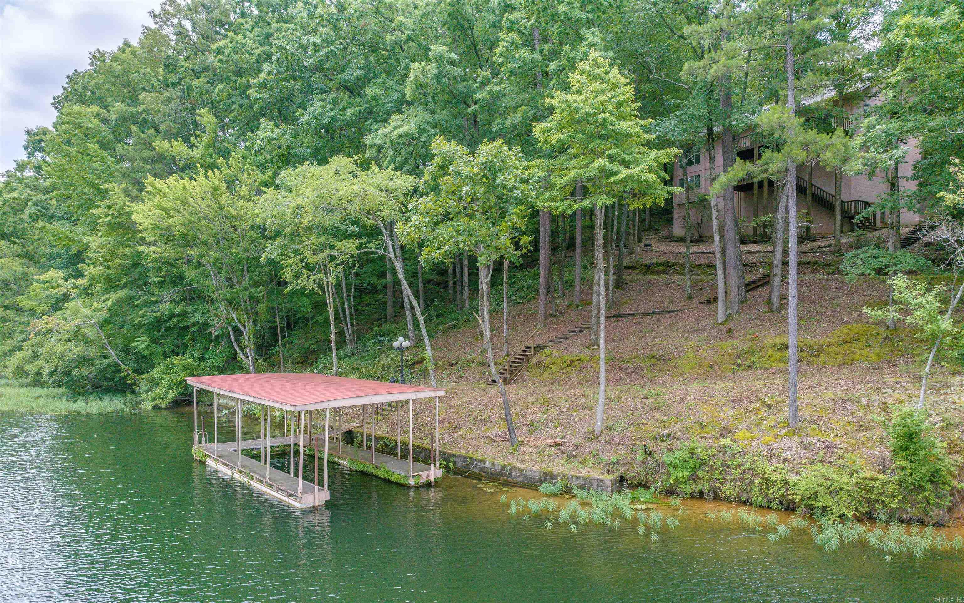 Lake Cortez WATERFRONT! 3Bed+Den/3.5Bath - Great Opportunity to be on the 3rd largest lake in HSV! Priced to allow for your own updates, this home is nestled in the trees and has a NEW ROOF & GUTTERS! From the Pegged Oak Flooring to the Open-concept Double Island Kitchen, this home can be a true gem! Huge Skylights, Atrium-style Eating Area, Brick Fireplace, Huge Laundry Room, Central Vacuum System, Open-beam Ceiling in the Den with Built-in Cabinetry! The Primary Bedroom boasts Walls of Windows and an Ensuite with Soaking Tub and walk-in Closet! The lower level offers a Recreation Area, Bedroom and Guest Bathroom. Don't miss the Walk-in Storage Room under the home (perfect for a Workshop/Garden Supplies). Exterior paint, updated flooring and a little love would make this a GREAT INVESTMENT at this price! Lake Cortez is a 240 acre Full Recreational lake (water ski), one of 11 Lakes and 9 Golf Courses in 26,000 acre Gated Hot Springs Village! Area amenities: Tennis, Pickleball, Mini Golf, Indoor and Outdoor Pools, Fitness Center, Performing Arts Center, 20+ Miles of Walking Trails, 2 Marinas, 2 Beaches, and much more!
