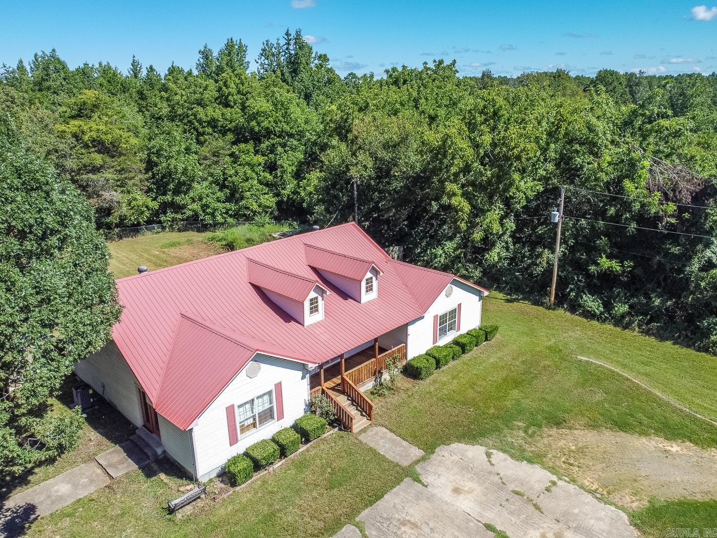 Welcome to Market 980 S Highway 305 of Searcy, Arkansas within the Beebe School District. Situated on a fenced and level 1 acre +/- lot is a sprawling ranch style house wrapped in vinyl and topped with a metal roof. Featuring 2,831 sf of well laid out living space that has been recently updated with laminate flooring, fresh paint throughout, and HVAC. The common areas contain a supersized living room, eat-in kitchen with bar seating, pantry, and laundry room. The Master wing holds a generous bedroom w/ exterior access, garden tub, walk-in shower, vanity, and walk-in closets. The spare wing holds three bedrooms, a full bath, and so much storage. The Sellers love the paved streets, remote location, the open floor plan, big bedrooms, and all the closet space. You'll love the wide open front porch, enclosed patio, 800 sf floored, wired, and cooled shop, outbuilding, storm shelter, dog cover, circle drive, and tree lined views. A Country Lovers dream property conveniently located near all the amenities Searcy has to offer. Call today to schedule your tour and make this house your home.