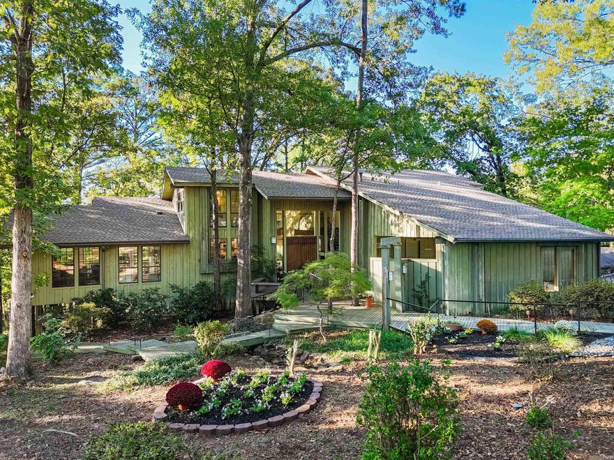 This one-of-a-kind mid-century modern home is full of character, light, and style! It is Conveniently located in the heart of Clarksville has access to the Spadra Creek Nature Trail. Offering over 6,000 sq ft of living space across three floors, plus a heated and cooled detached garage and showroom with a half bath, for a total of more than 8,500 sq ft. Inside you’ll find 5 bedrooms, 3.5 baths, and an office, all filled with windows that bring in natural light throughout. The main bedroom features a cozy fireplace, doors that open up to a covered porch, perfect for relaxing, and a large bathroom ensuite.  A convenient elevator connects the main and lower level for easy access. Unwind on the expansive decks and porches, with a BEAUTIFUL view that makes you feel like you are on a retreat.  The thoughtful design and character makes this home truly unique.