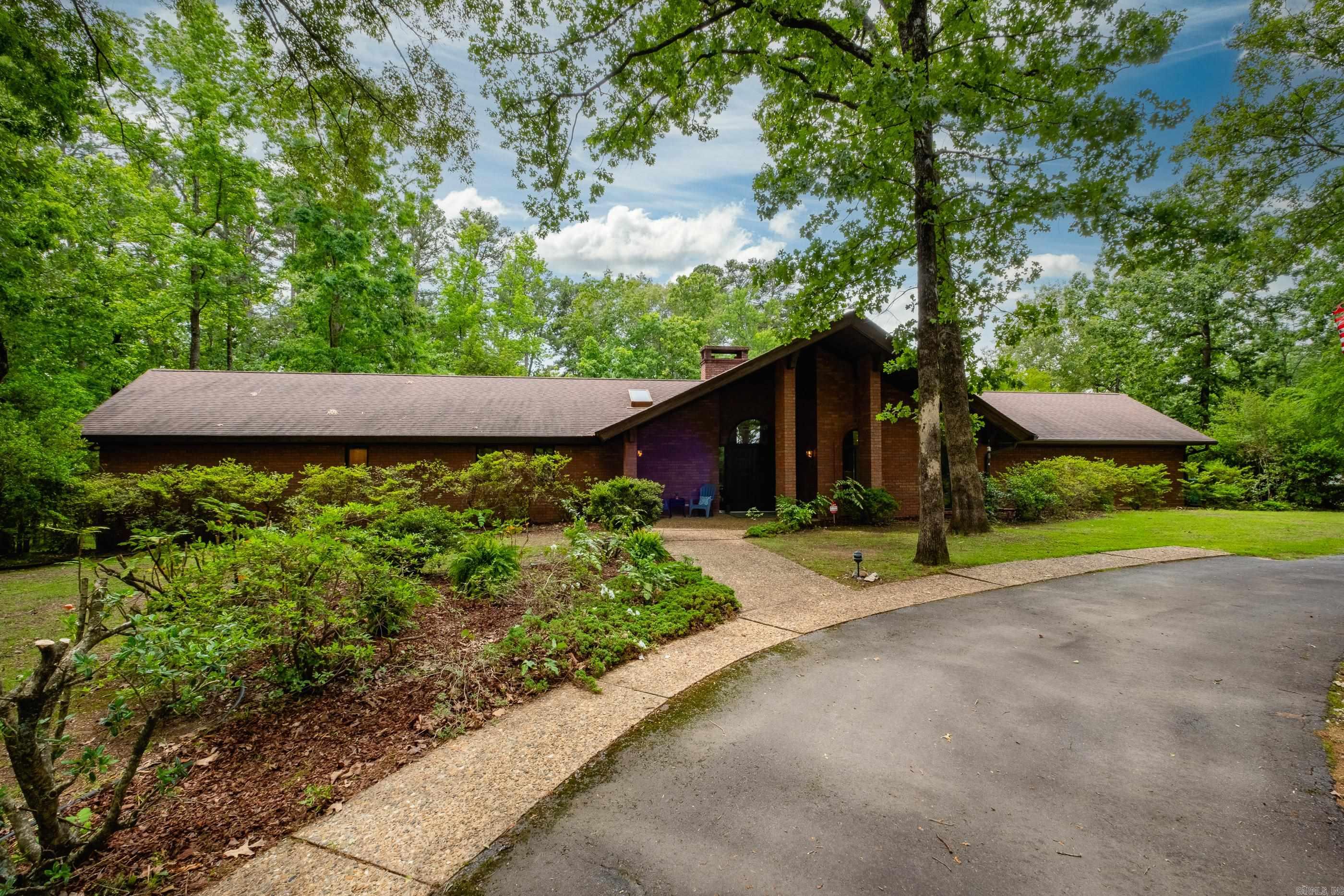 Welcome to your private retreat nestled on appox 4.5 +/- acres of serene woodland, the perfect blend of modern amenities & natural beauty. This custom-built home features an open floor plan centered around a stunning two-story brick fireplace—the heart of the home. The chef’s kitchen is a culinary dream, equipped with an AGA range, often called the "Rolls-Royce of stoves". Just off the front entry, you'll find a formal living area or office space. The spacious primary suite offers a private escape with its own deck—perfect for enjoying your morning coffee. Don’t miss the basement wine cellar that can serve as a storm shelter. Step outside onto the oversized deck, ideal for outdoor entertaining or simply relaxing in the breathtaking, park-like surroundings. In addition to the main residence, the property includes a detached 750 sq ft studio apartment (not included in the main sqft). This versatile space features a full kitchen, bathroom, workshop & private patio-perfect for guests or creative pursuits. Enjoy energy efficiency and peace of mind with a Tesla Powerwall, solar panels, and a Tesla car charger—keeping your home powered and your utility bills low. Agents, see remarks.
