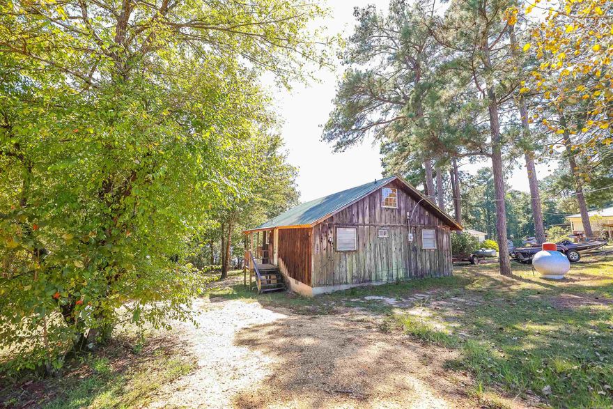 Charming cedar chalet-style waterfront home!  The high vaulted ceiling provides an airy feel with natural light providing a view of Upper White Oak Lake.  Enjoy lake life from the back deck, or on the water from your own dock/boat shelter.  The layout offers two downstairs bedrooms, and one loft bedroom.  Newer metal roof and HVAC unit!  Sitting on 1.5 lots, this property is a unique find! Buyers, please be aware that Arkansas Game & Fish have covenant restrictions governing the area.  **Seller is offering a $3,000 dock allowance for modifications/repairs**