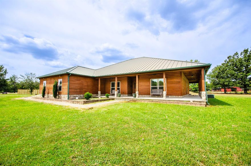 MOTIVATED SELLER! Would love to work with buyers & their agent to make this home theirs. Well maintained custom log style home with metal roof, solid wood doors, sunroom with accent antique stain glass, 5 burner gas stove, copper kitchen sink, wood burning fireplace, wrap around porch. 17 seer HVAC, on demand hot water heater, freshly painted garage, extra pull outs in the kitchen, pantry, oversized master bathroom and with a large, tiled shower, hardwood floors and tile throughout, extra built-ins in the closets, 9 and 10 ft ceilings. All gas home outside has just been re-stain for years of enjoyment.  Just surveyed, Agents see showing remarks and for more info. Privacy fence to the left of the property's driveway. New decking boards on the back of home.