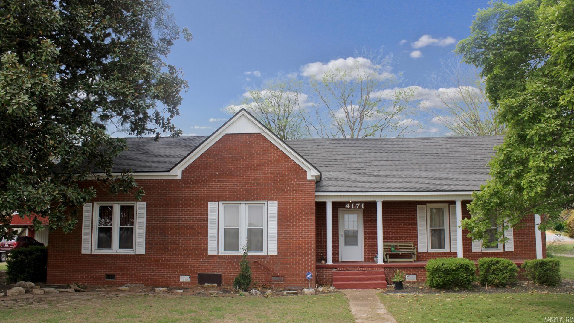 Say hello to 4171 AR-90E, Pocahontas: This beautiful red-brick home just got a BRAND-NEW ROOF! Additional updates include a new water heater, stainless steel kitchen sink, bathroom sink, faucets & toilet, carpet, linoleum, fresh interior paint, and newer tilt-in windows with a transferable warranty. Experience timeless charm with modern updates in this beautifully maintained 1910-built home offering over 2,100 sq ft on 1.4 peaceful acres (+/-) just 6.5 miles from Pocahontas. Rustic details like Amish woodworking, original fixtures, and a basement for safety from storms or storage room add to its charm. This move-in ready retreat includes central heat and air, a gas log fireplace, and propane backup in case of power outages. Enjoy the large front porch and screened-in side porch surrounded by mature pecan, walnut, magnolia, and tulip trees. Outside, you'll find a well-house for gardening or livestock, a nice metal 30x22 shop with electricity & 220 outlet for RV hookup, a 3-car carport, and a separate 1-car carport. With two spacious living areas, this property blends history, comfort, and homesteading potential—all just minutes from town! **New roof has transferrable warranty!**