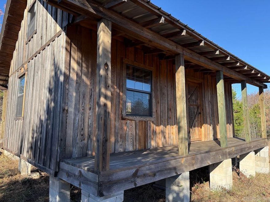 Tucked back in the quiet hills near Oxley, AR, this rugged yet inviting 10-acre tract offers rare privacy and simplicity. The land is surprisingly level for the Ozarks and features a healthy mix of small hardwoods, brush thickets, and pockets of dense cover. Trails wind easily through the property, leading to a small pond tucked in the timber that draws deer and turkey and adds a peaceful spot to enjoy quiet mornings. A solid internal road and well-maintained access road make getting around simple. At the center sits a small unfinished cabin with rustic wood siding, a metal roof, covered front and back decks, and a spacious loft—ready for someone to finish out as an off-grid escape, hunting basecamp, or weekend hideaway. Electric and rural water are less than a quarter mile away if desired. Despite its seclusion, the property is close to the Ozark National Forest, Leslie, and Mountain View with its music, charm, and outdoor recreation. Additional adjoining acreage are available for those wanting more room to build, explore, or create a private retreat.