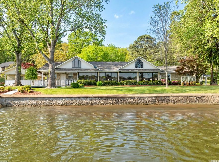An exceptionally rare find on Lake Hamilton! This expansive Lake Hamilton property spans just under one acre across two beautifully manicured lots and boasts approximately 200 feet of prime lake frontage with year-round water and stunning panoramic views. The main residence is thoughtfully designed with a single-level layout and no steps, offering ease of access throughout. Inside, you'll find 3 spacious bedrooms and 2.5 bathrooms, including a generous primary suite with a private en suite bath. Additional features include an open layout, cozy fireplace, a sunroom, office and large windows framing lake views from nearly every room. A new roof adds peace of mind and lasting value. Also on the property is a charming 300 sq. ft. guest house studio apartment with bath, complete with an attached workshop—perfect for guests, hobbies, or additional rental income. Outdoor living is just as impressive, with impeccably landscaped grounds, a two-car carport, a covered boat slip with lift, and plenty of room to relax or entertain. This is the kind of property that rarely comes available—offering privacy, space, and an unbeatable lakeside lifestyle.