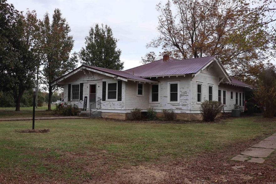 Charming home in a Small Town. Two extra rooms, could be used for dining, a sitting area, or an office. Vintage stove still in working order. Double doors, archway, swinging kitchen door. Original wood floors. Two car garage, in law apartment above. All new electric, half of the home has new windows. Will be sold as is.