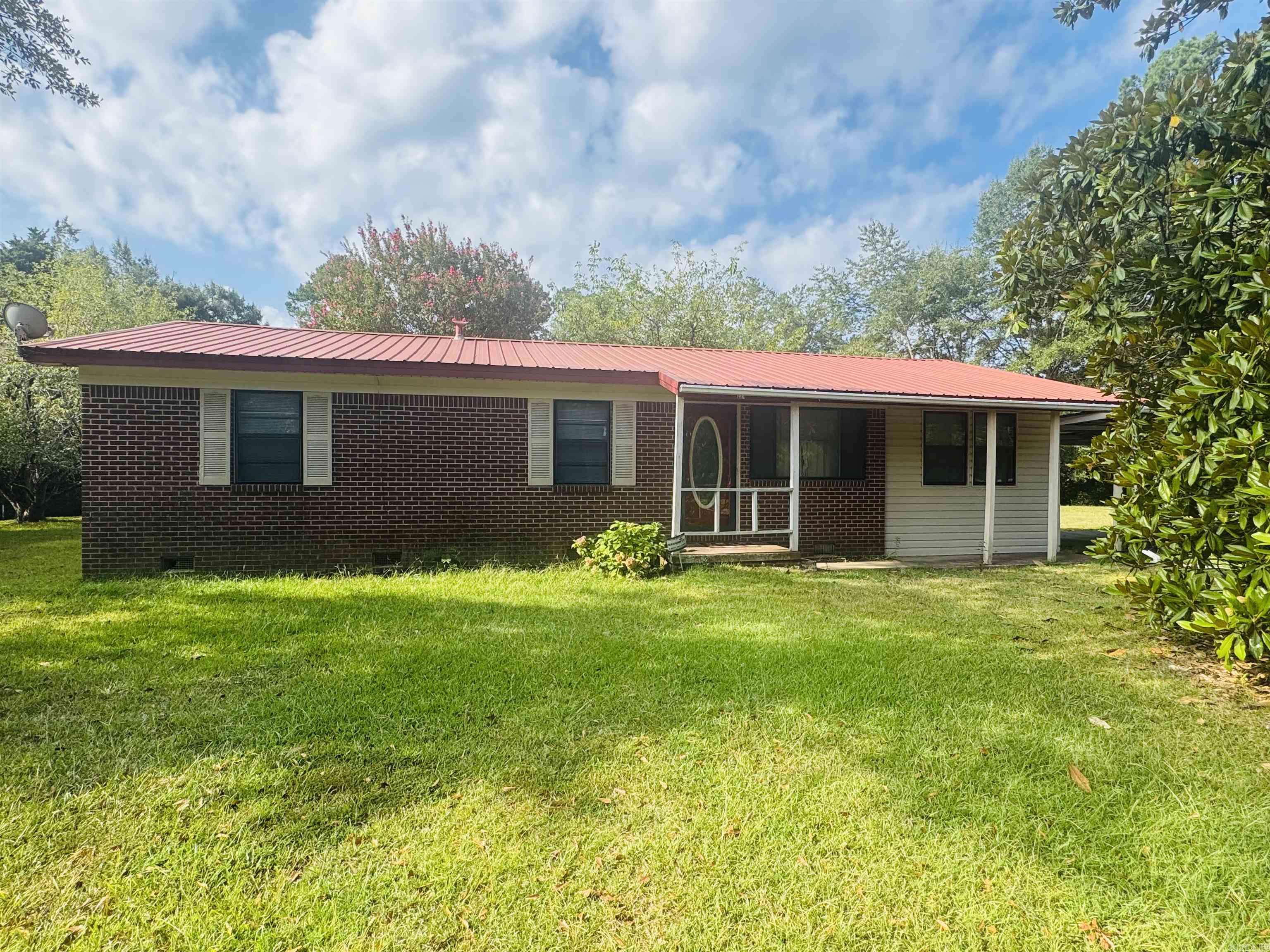 Solid Brick Home PLUS Extra Lot 3 bed 2 bath home located on a corner lot with bonus lot included- ideal for expansion or future investment. This home offers a large living area with vinyl flooring, eat in kitchen, gas cook top, walk-in shower and updated vanity in guest bathroom. Master bed and bath are located separate from guest bedrooms allowing for more privacy and relaxation. Enjoy central heat and air, 2 car carport, and a covered patio. This home offers lots of potential!