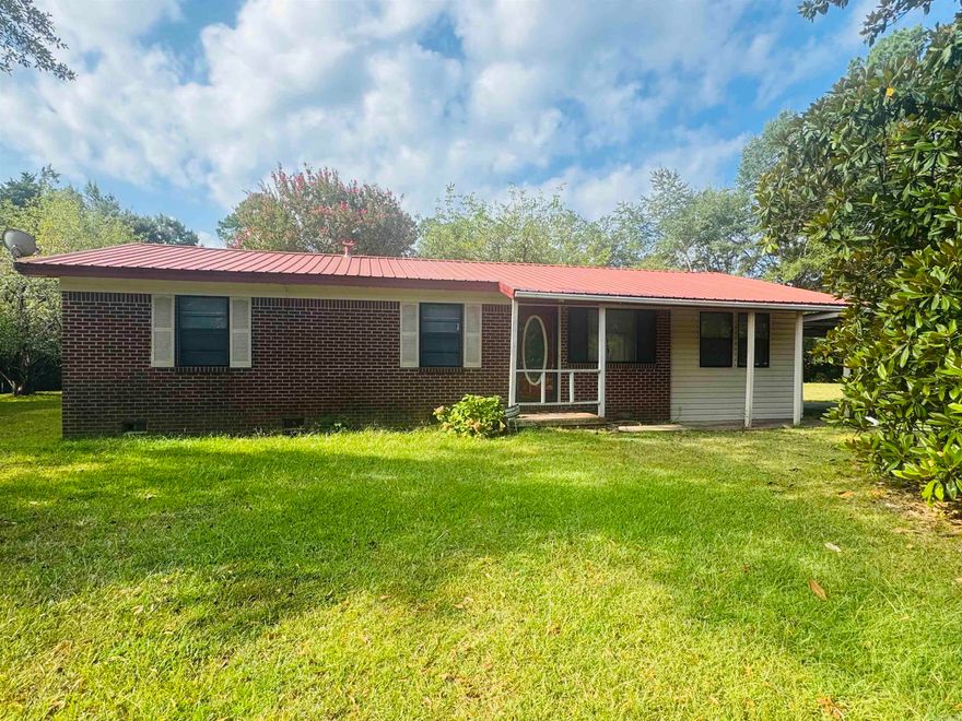 Solid Brick Home PLUS Extra Lot 3 bed 2 bath home located on a corner lot with bonus lot included- ideal for expansion or future investment. This home offers a large living area with vinyl flooring, eat in kitchen, gas cook top, walk-in shower and updated vanity in guest bathroom. Master bed and bath are located separate from guest bedrooms allowing for more privacy and relaxation.  Enjoy central heat and air, 2 car carport, and a covered patio.  This home offers lots of potential!