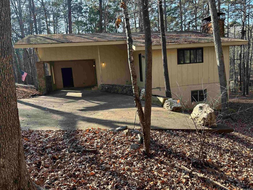 Come check out this 3-bedroom 2-bathroom fixer-upper home nestled in the woods of Hot Springs Village.  Vaulted ceiling in the living room, galley kitchen, nice size utility room with ample storage space. Refrigerator and cookstove convey. Has a wood burning fireplace upstairs and downstairs. Has a large workshop area under house. Roof is being replaced at seller's expense.    AGENTS SEE REMARKS