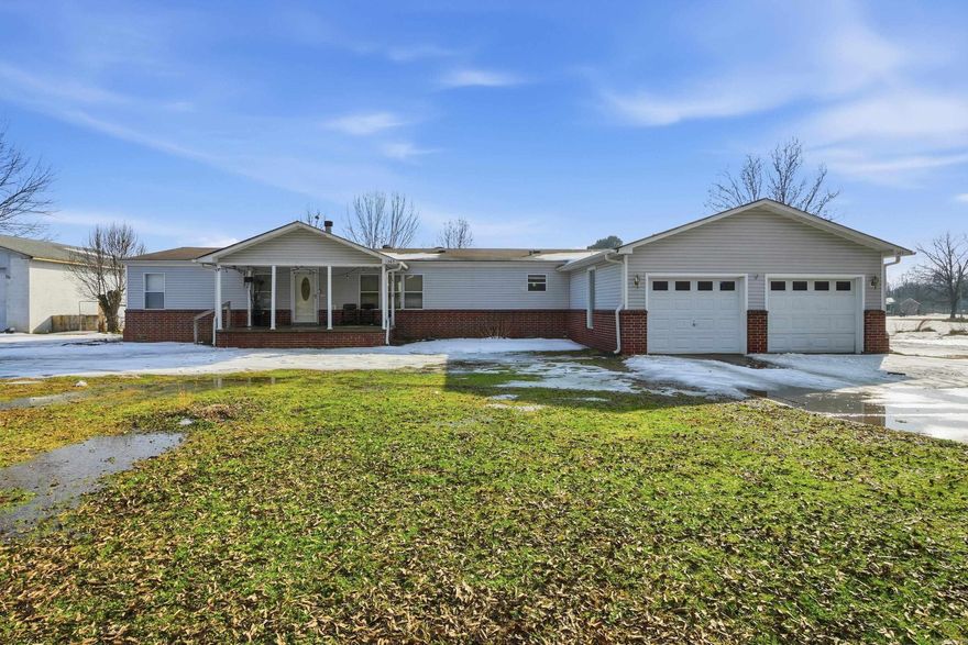 Welcome to this spacious 4-bedroom, 2-bath mobile home featuring a desirable split floor plan, an updated kitchen, a cozy wood-burning fireplace, a two-car garage, and a relaxing back porch perfect for enjoying the outdoors. Situated on a double lot, this property offers plenty of room to spread out and make it your own. A large detached cinderblock shop with double doors provides excellent workspace or storage and includes electric and plumbing, ideal for hobbies, projects, or future expansion. The home has been lovingly used as a homestead and includes several fruit trees and bushes, along with space that has been used yearly for gardening. The property has also been set up for chickens and goats, making it perfect for those seeking a more self-sufficient lifestyle or simply extra space to enjoy country living. Additional updates include a new hot water tank, fresh paint, updated kitchen, new carpet, and double-pane windows for improved energy efficiency and comfort. This unique property combines comfort, functionality, and outdoor opportunity, a great place to call home!