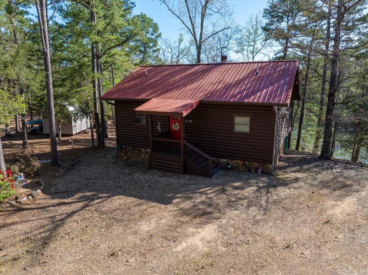Purchase your dream riverside retreat and cabin in a beautiful tranquil setting overlooking the Mountain Fork River in Western Arkansas. This one-bedroom, one-bath cabin built in 2006 has been both a residence and successful vacation rental. Its heated & cooled footprint is 768 SF (32’ x 24’) with a 150 SF Loft (10’ x 15’) above the kitchen. The exterior construction includes Douglas fir log siding, red cedar trim, and a metal roof. Nestled in the woods about 25 minutes from Mena, AR, enjoy the direct river view from the comfort of your roof-covered screened-in porch (16’ x 12’) while reading, eating a meal, or just taking in the scenery. Grill your favorite foods while hanging out on the other open half of the deck (16’ x 12’) overlooking the river. There are also steps leading to the river and a lower deck with built-in seating to take in a closer view of the river’s beauty. The property is a great spot for fishing, kayaking, and canoeing on this wide and expansive spot on the river. Sit outside and roast hot dogs and marshmallows while relaxing at the natural fire pit. This listing is also MLS 25014777, with 4.73 acres and cabin.