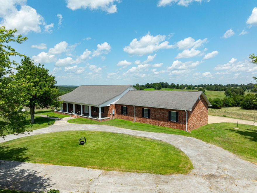 This expansive home on 35 acres in Ash Flat, AR, offers a picturesque setting with its white columns, long paved driveway, and lush pasture on either side. Automatic gates welcome you into the property, which includes a circular drive at the front and a spacious three-car garage area at the rear. Previously a horse farm, it still features amenities like a round pen and barn, all meticulously fenced and cross-fenced with two ponds and bordered by gravel roads and Highway 167.With this home you have about 2,356 sq ft on the main level, 2 bedrooms, 2.5 bathrooms, an office, living room, kitchen, dining area, foyer, several closets and laundry room.  The garage is off the office and has 1,225 sq ft +/-.  Down stairs you will have about 1,364 sq ft.  With the porch and deck off the back, this adds about 1,800 sq ft!  What a home with inside and outside living!
