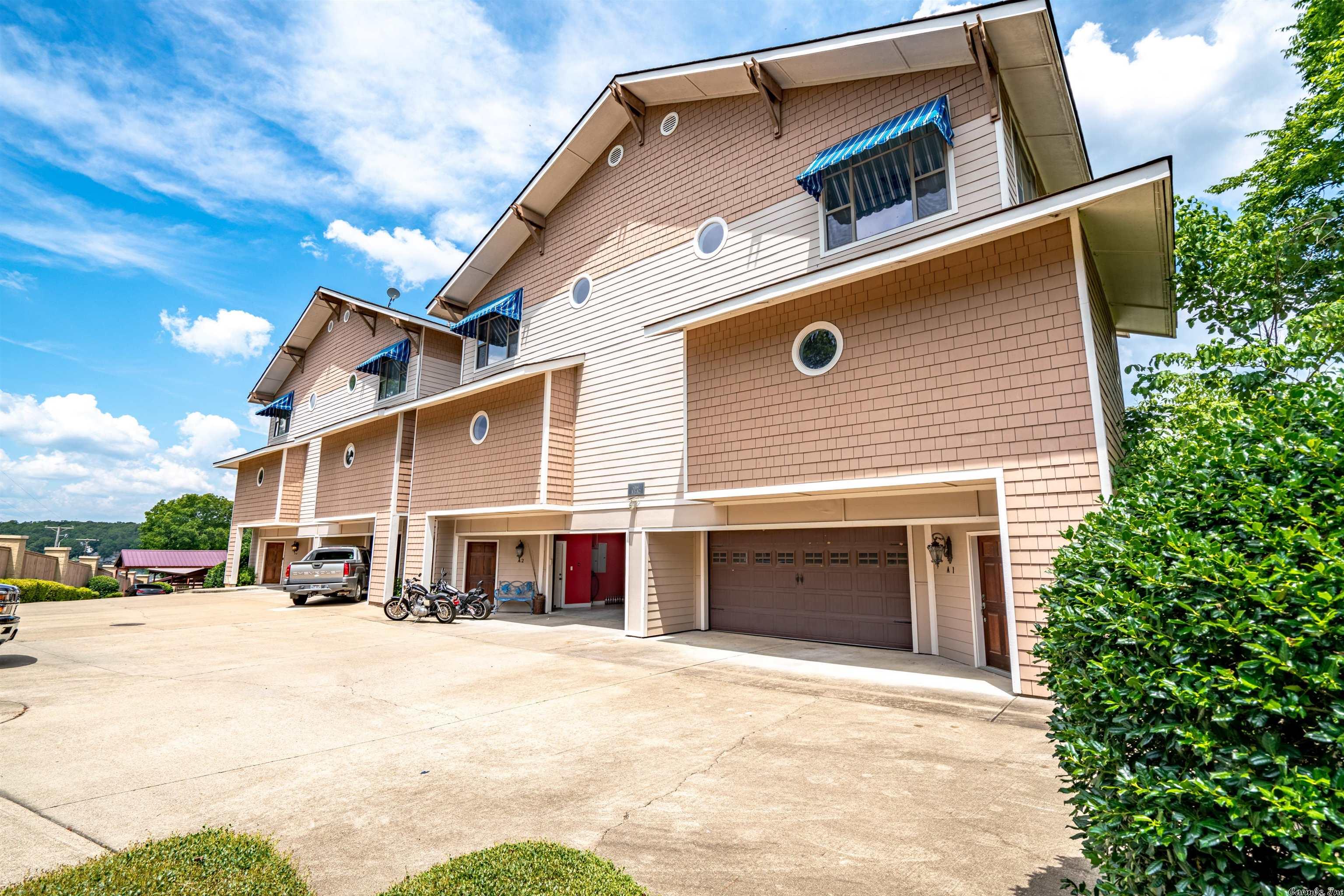 Talk about a lake condo on Lake Hamilton! In the gated subdivision of Bel Lago that has a 2-car oversized GARAGE and a community pool.... this SUPER CLEAN, NEVER BEEN LIVED IN condo has approx. 2426 sq. ft. 2DR and 2.5 Baths. Open Kitchen with custom cabinetry, lots of built-ins, granite countertops, double sink, trash compactor, breakfast bar and table area....Open floor plan, double crown molding with wood and carpet floors. Large (9'x27') storage room in back of garage is a real bonus!