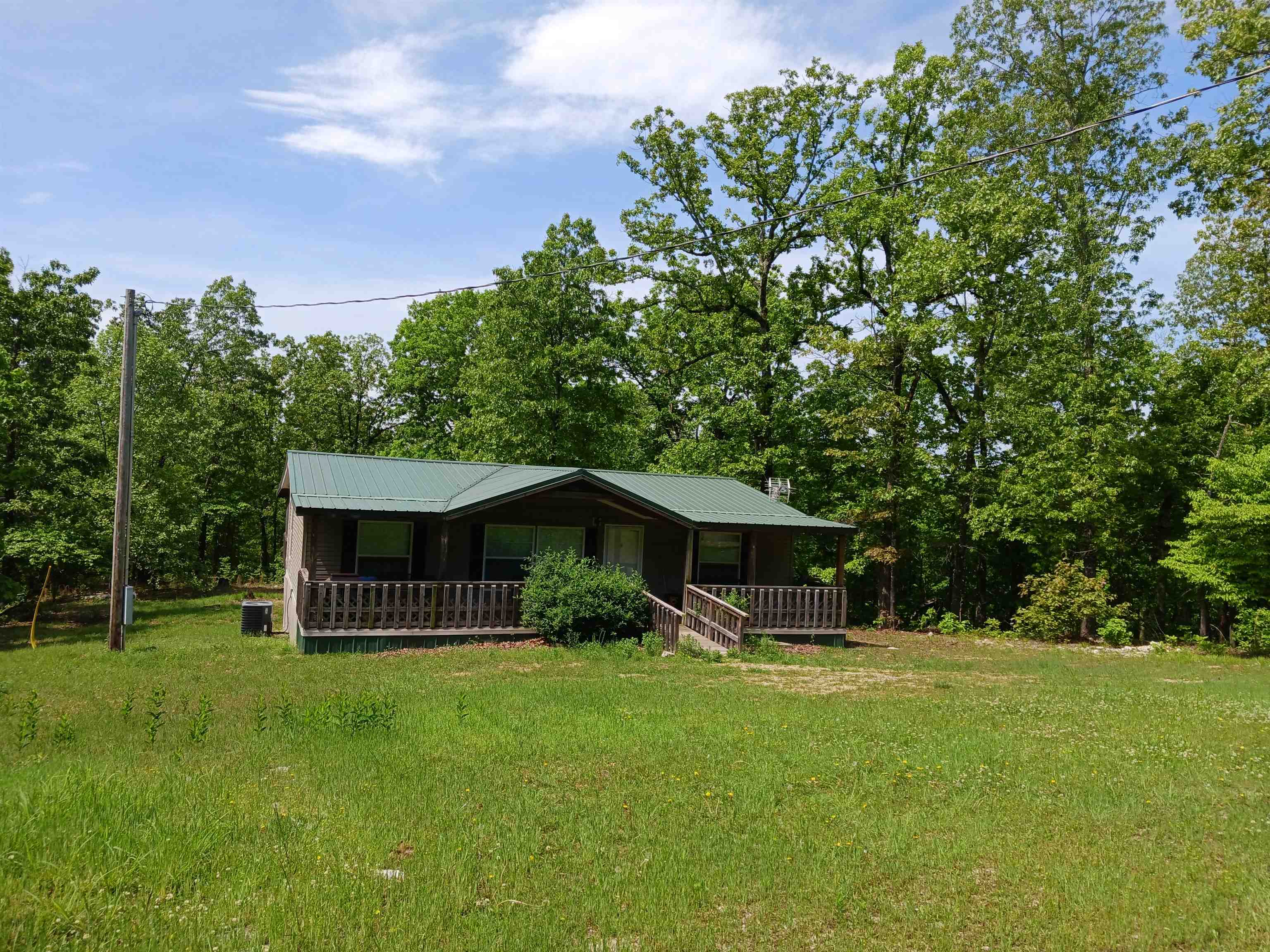 Immerse yourself in the quiet beauty of the Ozarks in this private home on 24+/- acres. Solid manufactured 3/2 home has wonderful covered front and back porches, gazebo, walk-in closet in master suite, appliances included, covered RV parking, storm shelter, detached shop building. No visible neighbors. Lots of wildlife to enjoy.