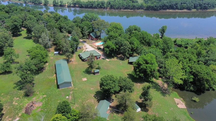 This stunning 7.47 acre property lies in the Ozark Mountains of North Central Arkansas and is a nature lover's paradise. The property features 4 beautifully constructed log cabins, nestled on the banks of the White River, offering breathtaking views of the river.  The largest cabin is 1288 square feet with 2 bedrooms and 1 bathroom, while the other 3 cabins offer 784 square feet of living space, with 1 bedroom and 1 bathroom each.  One of the property's standout features is the 2+/- acre stocked freshwater pond, complete with a year-round waterfall, which adds to the property's natural charm.  The property is located outside of city limits, offering peace and quiet, and a true sense of retreat. With 465 feet of riverfront views, it's easy to spend hours soaking up the beauty of the outdoors.  This property is the ultimate getaway, offering a unique opportunity to experience the natural beauty of the Ozark Mountains, while enjoying the comforts of home. It would make an excellent investment opportunity for anyone looking to own a multi-family property, retreat, or AirBnB rental income producing property.   Don't miss out on this once-in-a-lifetime opportunity. Listed for $825,000!