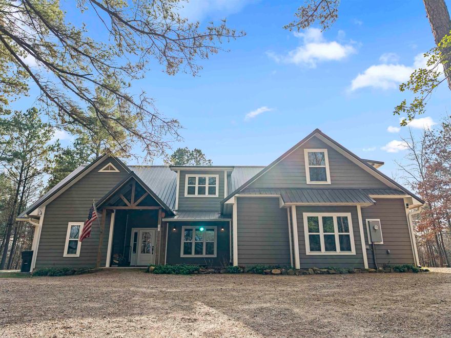 An elevated homestead designed with the same care and refinement as a luxury estate. Nearly 8 private acres and just minutes from the Caddo River, this exceptional property offers two thoughtfully crafted homes where luxury and sustainability exist in perfect balance.   The 3,600± sq ft main residence features 5 bedrooms and 3 baths with abundant natural light, vaulted ceilings, bamboo flooring, an Arkansas-shaped stone fireplace detail, bedside sconces, built-in shower niche, oversized garage, and a 50-year metal roof. Systems supporting self-sufficiency add long-term value.    The 1,300± sq ft guest house offers 2 bedrooms and 1 bath with a cozy wood-burning stove, custom built-ins, stainless appliances, and inviting front and back porches-ideal for guests or extended family.  Outdoors, the property is polished and productive with raised garden beds enriched by 100% organic compost, fruit trees, blueberries, blackberries, and curated culinary and medicinal plantings. A greenhouse, woodshed, goat pen, chicken coop, and playhouse complete the setting. A full plant list is available.  An exceptional luxury homestead, carefully designed and beautifully maintained.