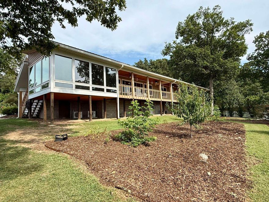 Discover one of the finest views in Mountain View from this 4 bed, 3.5 bath home overlooking the scenic Sylamore Creek. Sitting on 3.97 acres, this home features vaulted ceilings and an open layout filled with natural light. Each bedroom includes its own private bathroom and large windows framing the stunning surroundings. A cozy sunroom off the front of the house offers year-round relaxation, while a second sunroom off one of the main bedrooms provides a private retreat with unmatched views. The finished basement includes a family room, one bedroom, half bath, and a FEMA storm room for added peace of mind. Solar panels keep the electric bill around \$12/month, and a routinely serviced Generac generator adds security. Outside, you'll find TWO detached 2-car garages providing ample parking space or extra storage, and another garage connected to the dog kennels—perfect for animal lovers or hobby use. The property also features a greenhouse, a chicken coop with run, peach and apple trees, blueberries, elderberries, and beautiful landscaping. This home combines comfort, sustainability, and panoramic views in a truly exceptional setting.