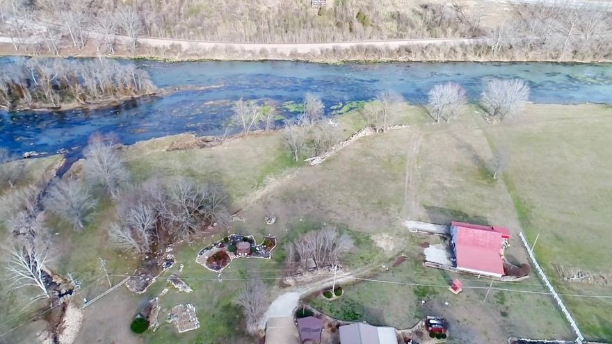 Situated on 3.90 acres within the city limits, this 2-bedroom, 2-bath all-brick home offers 2,394 square feet of living space in a truly special setting. The property boasts Spring River frontage with a year-round creek, providing stunning views and a peaceful atmosphere rarely found in town. Outdoor living is a highlight with a gazebo, covered patio, and beautifully maintained landscaping, perfect for relaxing or entertaining. A barn/shop building adds versatility for storage, projects, or recreational use.  The home features a solid layout with several important improvements already completed, including a newer HVAC system, roof, and stainless steel dishwasher and refrigerator. While updates are still needed, this property offers tremendous potential for customization and value enhancement. With its combination of acreage, water features, and convenient location, this is a unique opportunity to own a riverfront property with room to grow.