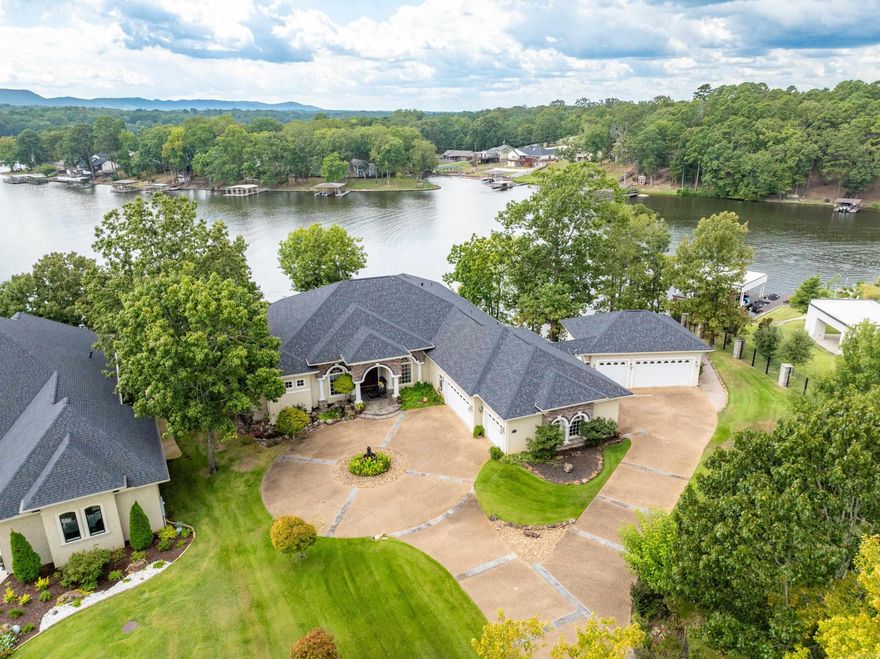 Welcome to your own private oasis on the pristine shores of Lake Hamilton! This stunning waterfront home boasts 270 feet of frontage, providing you with breathtaking views and direct access to the water. Located on a cul-de-sac, and in a quiet neighborhood of upscale homes. Upon entering the property, you will immediately take notice of the outstanding landscaping. There is a peaceful custom 230'lake-fed creek that runs from the front of the home all the way down to the sparkling waters of the Lake Hamilton. Imagine sipping your morning coffee on the deck as you listen to the tranquil sounds of nature surrounding you. Step inside and discover a beautifully designed floor plan that offers ultimate privacy. The master suite is perfectly split from the other bedrooms, for privacy and comfort. Two guest suites are located off of the kitchen and family room area. No matter which one you choose, you will find beautiful lake views from everyone of them in this home! Need to get some work done? No problem - this home also features a convenient home office space. Large laundry room and half bathroom off the kitchen area. Open kitchen provides ample storage and cooking area. Continued...