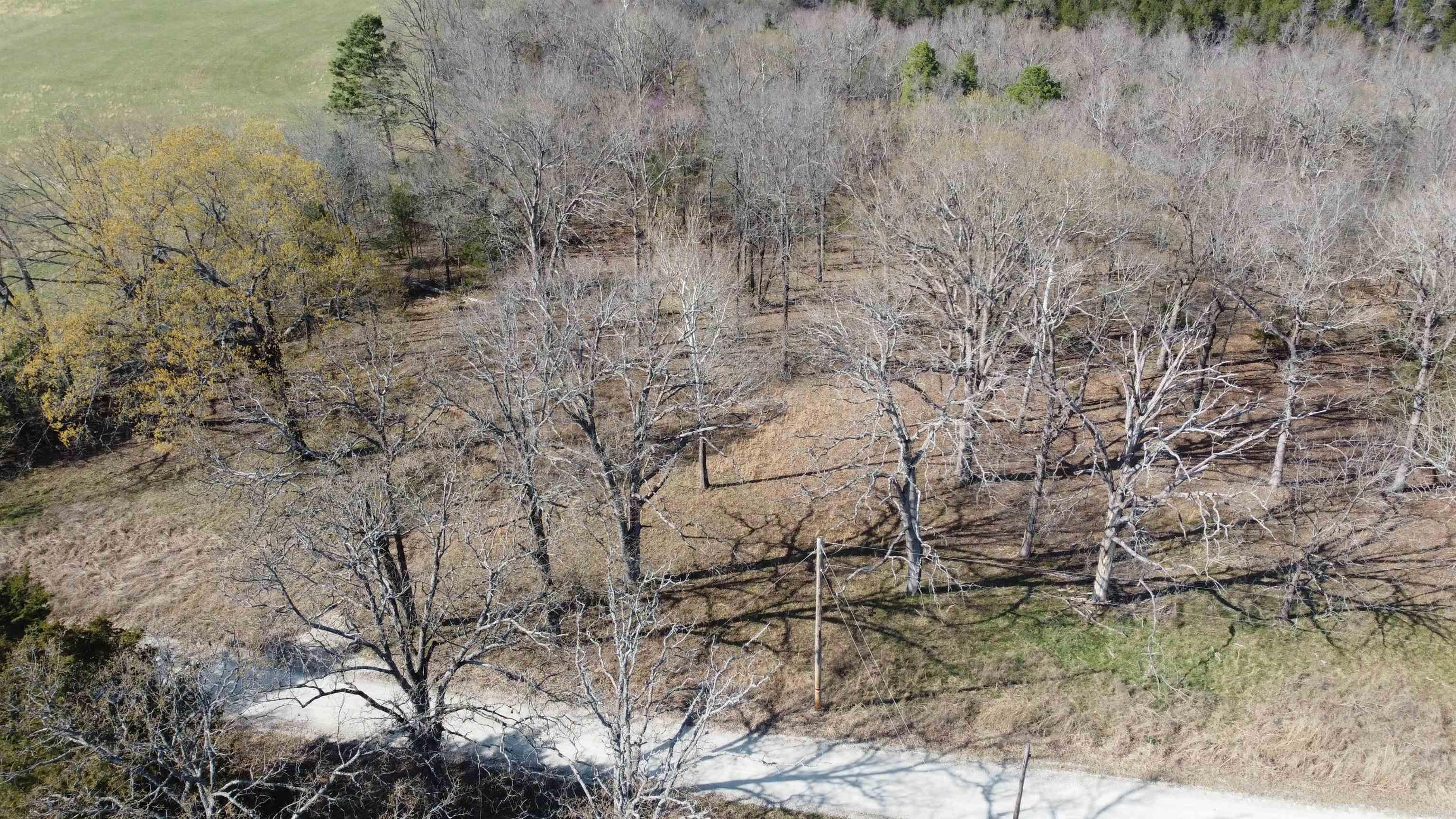 Perfect Setting for Your Getaway Retreat or Forever Home!! Discover 5.64 serene acres nestled in the Hillcrest Subdivision—two adjoining lots offering the ideal blend of privacy and convenience. Located just 1/4 mile off paved road, this gently sloping property features a mix of cleared space and mature hardwoods, making it ready for your dream build. Property offers ample of space for the avid gardener. Enjoy the tranquil sounds of nature and view the wildlife that resides in the area. Only an hour to Branson, MO. where you can enjoy entertainment, shopping, and dining. With electricity available, a drilled well already in place, and easy access, the groundwork has been laid for your next chapter. Enjoy the peaceful ambiance of your own private pond, and take advantage of direct access to Corps of Engineers land on Bull Shoals Lake—perfect for fishing, skiing, and all your favorite watersports. As an added bonus, a boat slip with a lift on a nearby community dock is available with sale, just minutes from the property. Whether you're looking for a relaxing escape or a place to call home, this unique offering has it all. Don't miss out on this one!!!