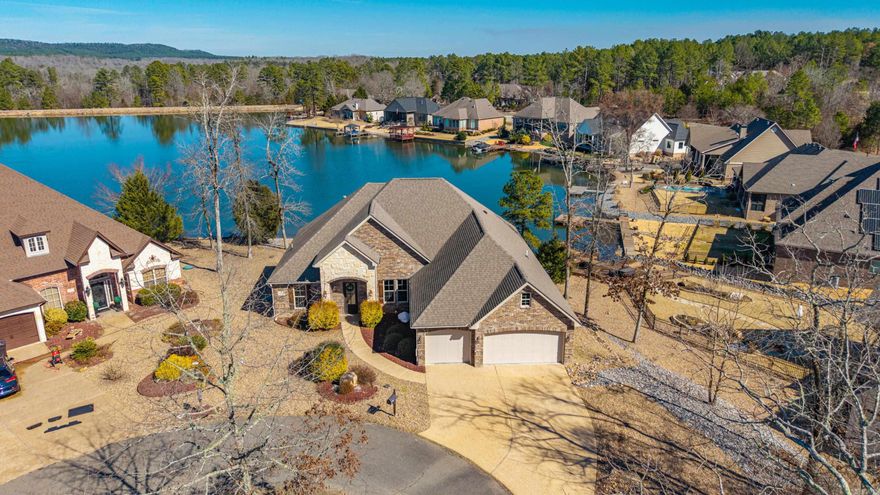 PREMIER LAKEFRONT & GOLF-AREA LIVING ON LAKE MARIA! Perfectly positioned at the back of a quiet cul-de-sac in the heart of the Isabella / Santa María Golf area, this Lake Maria waterfront home offers panoramic open-water views stretching to the dam. Volume ceilings and crown molding elevate the interior, while rustic cherry cabinetry brings warmth and timeless appeal to the kitchen. The living room showcases custom built-in cabinets and exceptional storage throughout the home. Outdoor living shines with a covered back deck and patio overlooking the lake—ideal for entertaining or unwinding after a day on the course. A maintenance-friendly backyard leads to a private swim dock for easy lake access. The spacious garage features a walk-up staircase to oversized attic storage, a rare and valuable bonus. Located in Hot Springs Village, residents enjoy 11 lakes, 9 championship golf courses, pickleball and tennis courts, fitness centers, miles of trails, and a secure gated lifestyle. This Lake Maria home offers the ultimate blend of waterfront serenity and golf-centric living.