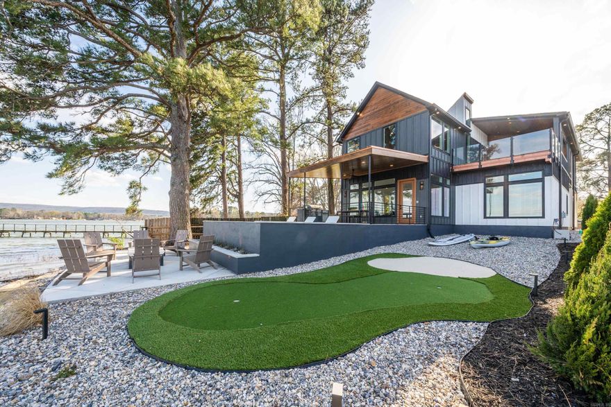 Welcome to Emerald Point, a stunning 4-bedroom, 4.5-bath lakefront home on Lake Hamilton in Hot Springs, Arkansas. Newly built and carefully designed, this home blends style, comfort, and fun for an unforgettable lake experience. This property is an active short-term rental (STR).  Three bedrooms feature king-size beds for ultimate comfort, while one bedroom offers four custom queen-size bunk beds, providing flexible sleeping options. Two bathrooms are ensuite, with two additional shared baths for convenience.  The two-story layout balances living and entertainment. The main-level kitchen has modern appliances for easy cooking, and upstairs, the game room includes air hockey, shuffleboard, arcade games, Pop-a-Shot, a Nintendo Switch, and a putting green with golf pong. Outdoors, enjoy corn hole, two kayaks, and two paddleboards for lakefront fun.  Boat dock makes boating simple, and the balcony with a gas grill is ideal for meals with sweeping lake views. Every detail at Emerald Point is designed to combine comfort, activity, and relaxation in one exceptional home.  From lively game nights to adventures on the water, this home delivers a lakefront experience that’s