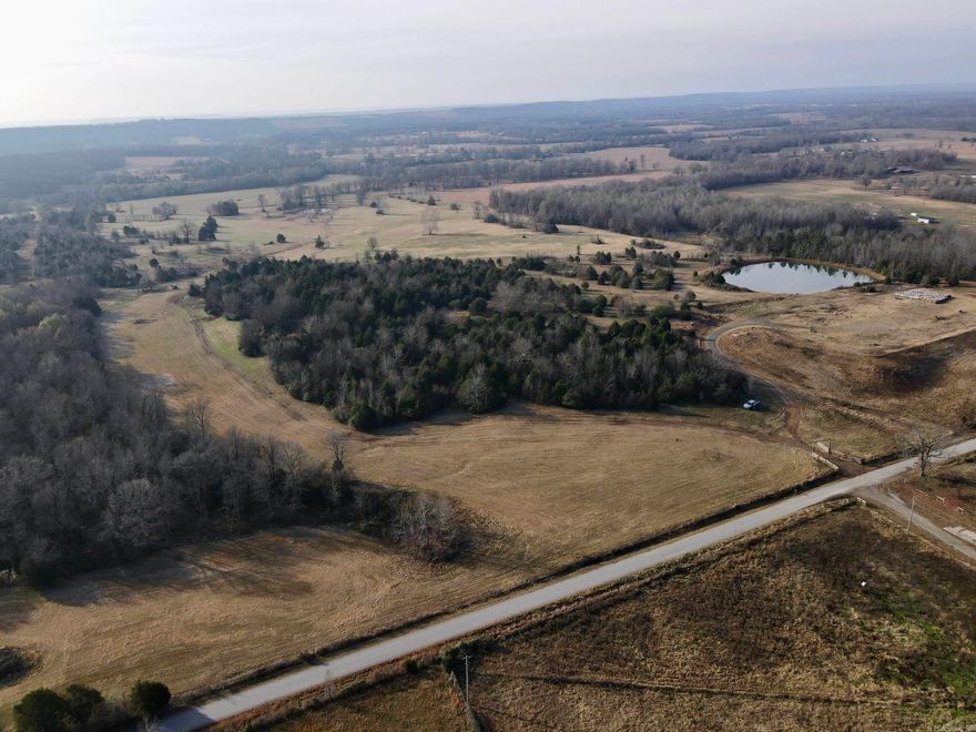 This exceptional multi-use farm offers a rare combination of location, functionality, and natural beauty. With a gated entrance and over a quarter mile of paved road frontage, the property delivers outstanding curb appeal from the moment you arrive. The entire boundary is fully and securely fenced, enclosing gently rolling terrain with a beautiful blend of open pasture and scattered timber thickets - ideal for livestock, wildlife, or future homesites.  Two ponds provide reliable water sources for cattle, horses, or wildlife, and offer the added bonus of casual fishing opportunities. An established internal road system allows easy access throughout the property, making daily farm operations, hunting, or recreational use incredibly convenient.  This versatile tract is ideal for a wide range of uses, whether you envision a private homestead, a working hay or cattle farm, a family recreational retreat, or simply a high-quality hunting property. The area is renowned for its excellent deer and turkey hunting, and the landscape boasts all the natural features necessary to attract and sustain abundant wildlife.