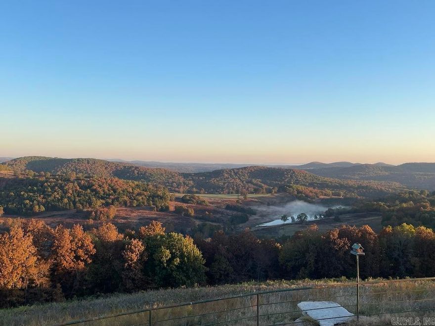 If you’ve been searching for a once-in-a-lifetime Ozark property, this is it. Tucked at the end of a gravel county road behind a deeded easement, 830+ private acres unfold in complete seclusion. Perched high on a ridge, the custom two-story home overlooks rolling valleys and distant mountains, with a massive deck made for sunrise coffee and spring gobbles. Large windows, an updated kitchen, fireplace, finished basement, and three-car garage blend comfort with practicality. The home sells furnished and includes ATVs, deer stands, and feeders. A large shop with living quarters provides ample storage for equipment and ranch needs. The land is gently rolling with 3+ miles of trails, established food plots, mature timber, pasture, and a proven wildlife management plan producing trophy whitetails and abundant turkey. Creeks, springs, and a fully stocked five-acre lake complete the setting. This isn’t just acreage—it’s a turnkey Ozark legacy built for generations.