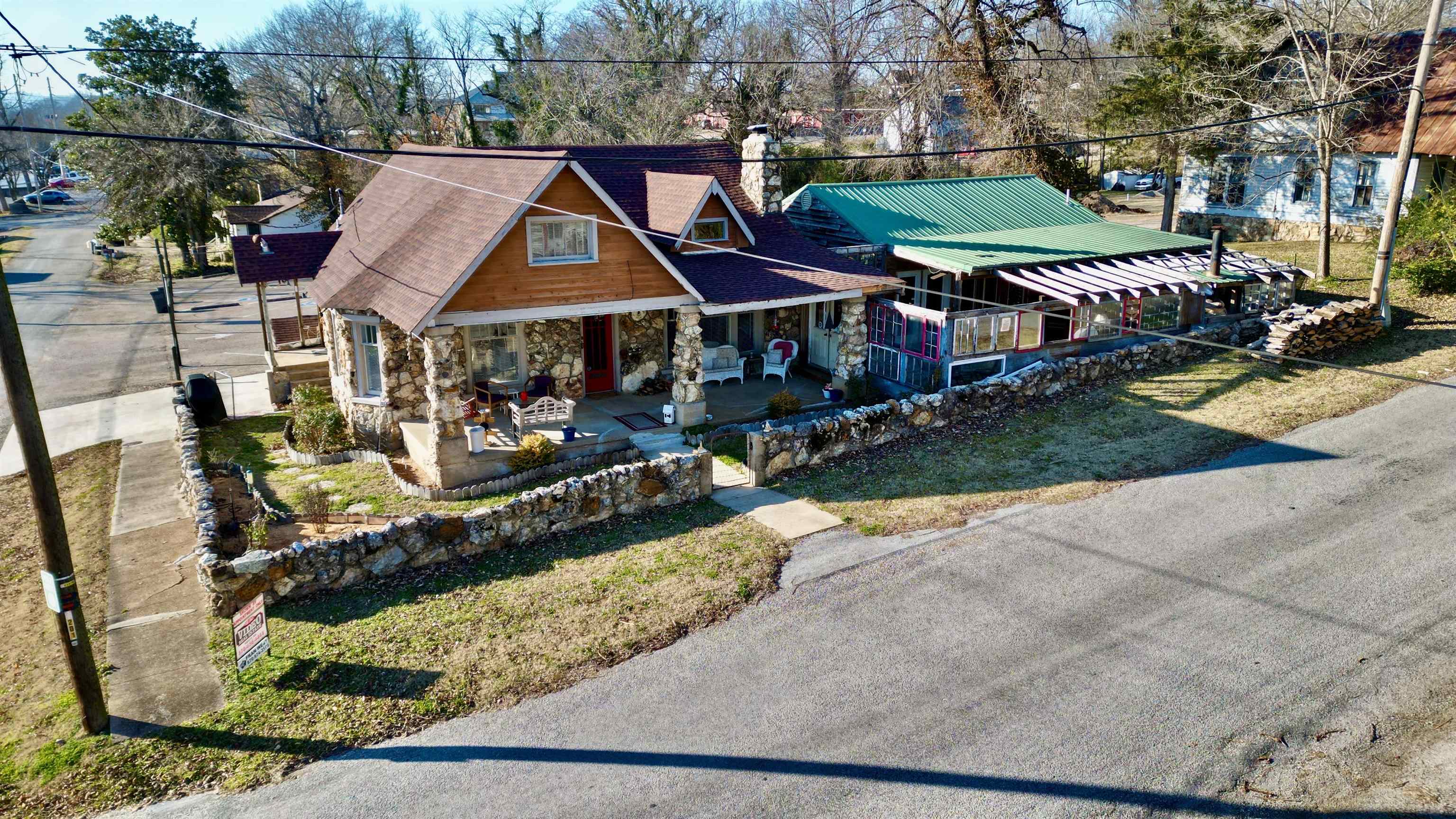 This Historic residential/commercial is on the Historic Register of Arkansas homes. This native Rock and original stone/Cypress home was first constructed in 1925. Since then, the home has been updated and upgraded with modern day additions and amenities, but, still maintaining the charm and architecture of the early 1900 era.. The living room of the home features the original fireplace and wood flooring and a covered front porch .An addition was added which has been a popular gathering dinner/music eatery for locals and Nashville talent. Off the dining/entertaining area is an all season sunroom. Just 1/2 block from Hardy Main St. with all small town shops, boutiques, crafts, antiques, grocery, bank, post office and medical clinic. The lakes and South fork and Spring River are within walking distance offering rafting, canoeing, camping and other river/lake activities. Truly, a unique investment opportunity for a private living quarters with the addition generating income.