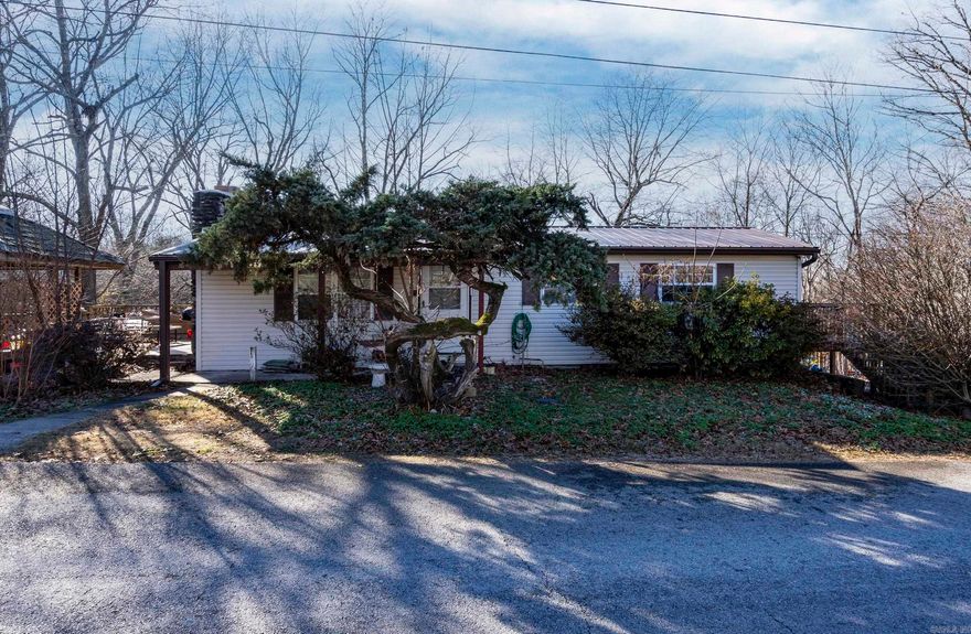 Fully updated and ready to enjoy, this inviting lake-area home offers the perfect blend of comfort, privacy, and outdoor living. Set on approximately 1.09 acres (+/–), the property provides usable land and a peaceful setting—ideal for a full-time residence, weekend escape, or family getaway.  Inside, thoughtful updates create a warm, welcoming atmosphere, featuring vinyl plank flooring, charming shiplap accents, and a beautiful stone fireplace. The functional three-bedroom layout (two upstairs, one downstairs) offers flexibility for family, guests, or a home office.  Step outside to enjoy the deck and gazebo—perfect for relaxing, entertaining, or soaking in the natural surroundings. Just about five miles from Hickory Creek Marina, the home is conveniently located for boating, fishing, and lake recreation.  Additional features include covered boat parking, dual-fuel heating for year-round comfort, and two storage buildings that provide ample space for tools, lake gear, and outdoor equipment. With recent updates already completed, this low-maintenance home is ready for its next owner to move in and start enjoying lake-area living right away.