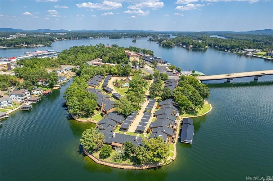 Located in the beautiful gated community of Hamilton Pointe and right in the heart of Hot Springs. This 3 bedroom/ 3.5 bathroom Lake Hamilton property offers unparalleled main channel lake views. Once you step inside you will be captivated by the spacious, open-concept living area with that seamlessly blends comfort and elegance. Large windows frame the picturesque lake views, and the skylights offer a flood of natural light and create a warm, inviting atmosphere. The living room opens onto a private balcony, where you can enjoy your morning coffee or unwind in the evenings. The condo boasts a well-equipped kitchen and modern appliances, making meal preparation a pleasure. The master suite offers a peaceful retreat, complete with a huge luxurious en-suite bathroom with built in's and a large WIC. In addition to a large living area with fireplace, the main level features a breakfast room and dining area. There is also a well appointed guest bedroom with private bathroom and walk in closet. The lower level offers a second living area with fireplace and a private guest suite. You will have no issue with storage. There is a indoor storage area on the lower level and an additional walk