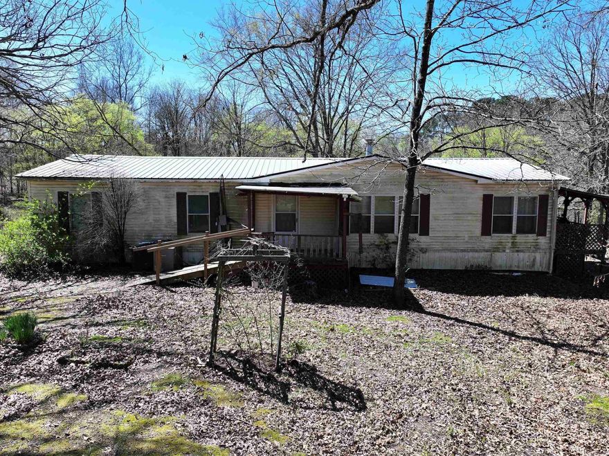 This mobile home situated on 4.25± acres with a creek would be the perfect project. Features 3 bedrooms/2 bathrooms, a wood burning fireplace, porches on front and back and is in need of some TLC.
