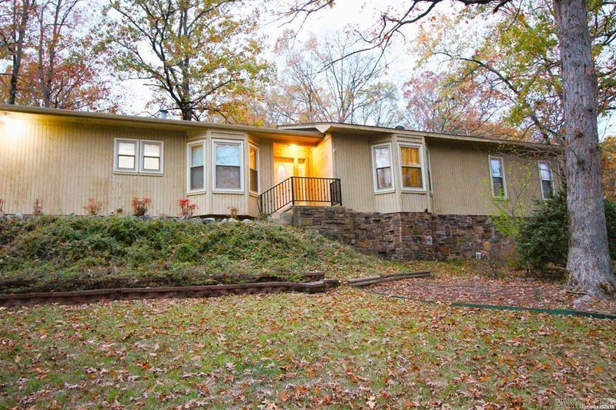 Welcome to this stunning 3-bedroom, 2-bathroom home nestled in the gated Hot Springs Village community. This beautifully maintained property boasts elegant hardwood flooring, a cozy fireplace, and built-in shelving that adds charm and functionality. The primary suite features a luxurious walk-in closet, built-in makeup vanity, linen closet, and two additional closets. Freshly painted interiors offer a clean slate for the next owner of this well maintained home.  The home also includes a spacious laundry room with a convenient sink. In the Living room, discover an inviting dry bar perfect for entertaining, and insulated windows for energy efficiency and comfort. Outside, enjoy the expansive patio, lush extra landscaping, and the convenience of a large corner lot. The attached 2-car garage offers plenty of room to store your car and toys.    Residents of this vibrant community can indulge in golfing, pickleball, and tennis, or take leisurely strolls by the serene lakes. Ideally located, the home is just minutes from shopping, dining, and top-notch medical care, making it a perfect blend of luxury, convenience, and lifestyle.