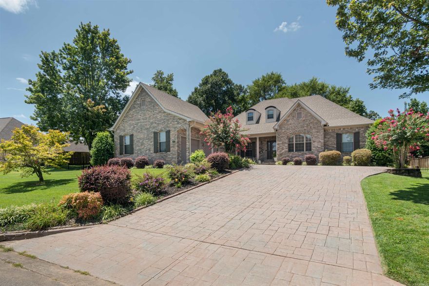 Experience the allure of luxury living at this exquisite home nestled in Hurricane Lake Estates. A grand entrance welcomes you with a meticulously detailed stamped driveway and beautifully landscaped surroundings enhanced by an effortless sprinkler system. Serenely positioned with views of the lake, this residence offers a captivating first impression.  Step inside to discover brand new hardwood floors, complemented by a charming stone fireplace and an inviting formal dining room, perfect for elegant entertaining. The garage and 8x10 shop feature newly installed epoxy floors, exemplifying attention to both style and practicality.  Recent upgrades include a bonus room addition, state-of-the-art HVAC system, a new hot water heater, and the added security of a Generac system. Outside, the backyard transforms into a private oasis with a tasteful back porch addition, shaded by mature trees and encompassed by a fully fenced yard with wrought iron in the front and wood fencing along the sides and rear.