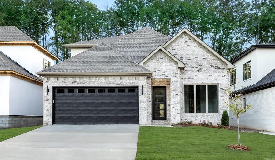 Welcome to 117 Kinley Loop, a beautifully designed home where sophisticated style meets everyday livability. The warm neutral brick exterior and unique designer light fixtures set the tone for the refined details you’ll find throughout. Inside, the open floor plan connects a stunning kitchen with double islands to a formal dining room and inviting living area anchored by a sleek black fireplace. Expansive sliding glass doors open to a covered patio—perfect for entertaining or relaxing outdoors. The primary suite is a luxurious retreat featuring a soaker tub, large glass shower, and designer finishes that make every day feel like a spa day. A double-sink vanity and expansive closet offer both comfort and convenience. A large laundry room and thoughtful layout make this home as functional as it is beautiful. Upstairs, you’ll find two additional bedrooms joined by a Jack-and-Jill bath with a separate toilet and shower area for added privacy. Blending modern design with timeless warmth, 117 Kinley Loop is a home that feels both sophisticated and inviting.