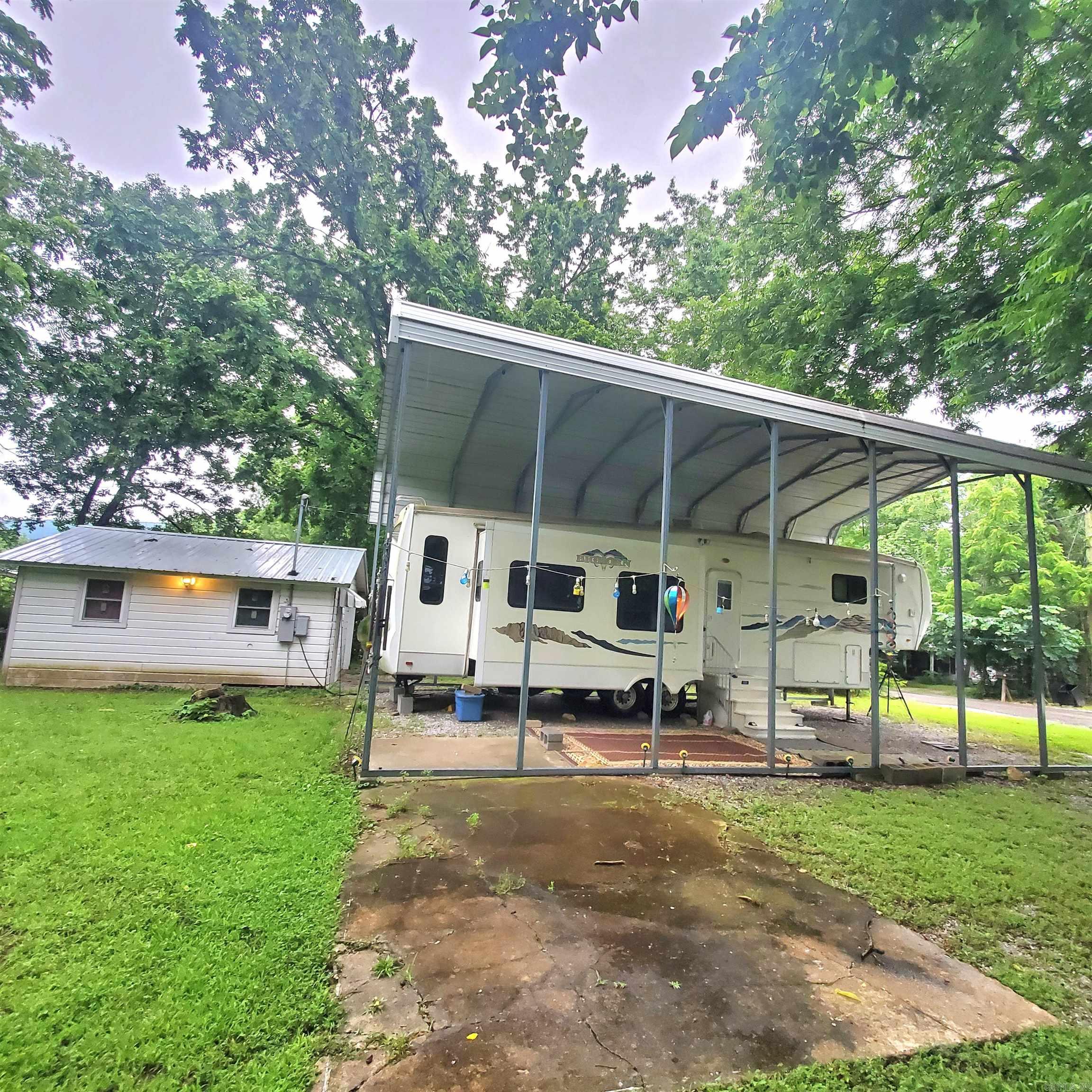 Very well maintained 5th wheel camper with new awning on .33 acre lot in town. Camper is 38 ft with 4 slides. Camper has always been kept underneath an awning or in a storage building. Has a 360 sq ft storage building with a new roof, with power so you will have plenty of storage space. Most of the furnishings will remain. This is within walking distance of all that the town square has to offer. Makes a wonderful vacation home!