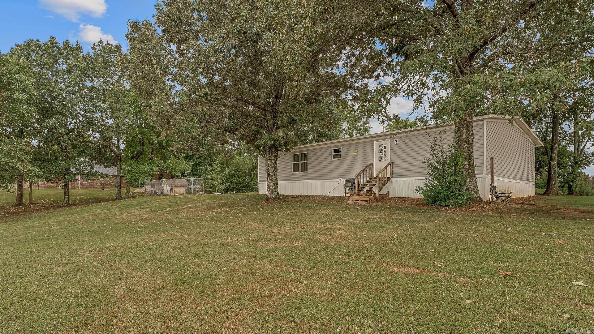 Spacious 4-bedroom, 2-bath mobile home situated on a full acre, offering both comfort and room to grow. This property features an open floor plan with a large living area, a functional kitchen with plenty of cabinet space, and a split-bedroom layout for added privacy. The primary suite includes a private bath, while three additional bedrooms provide space for family, guests, or a home office. Enjoy the peace and privacy of country living with plenty of outdoor space for gardening, recreation, or future additionsall just a short drive from town conveniences.