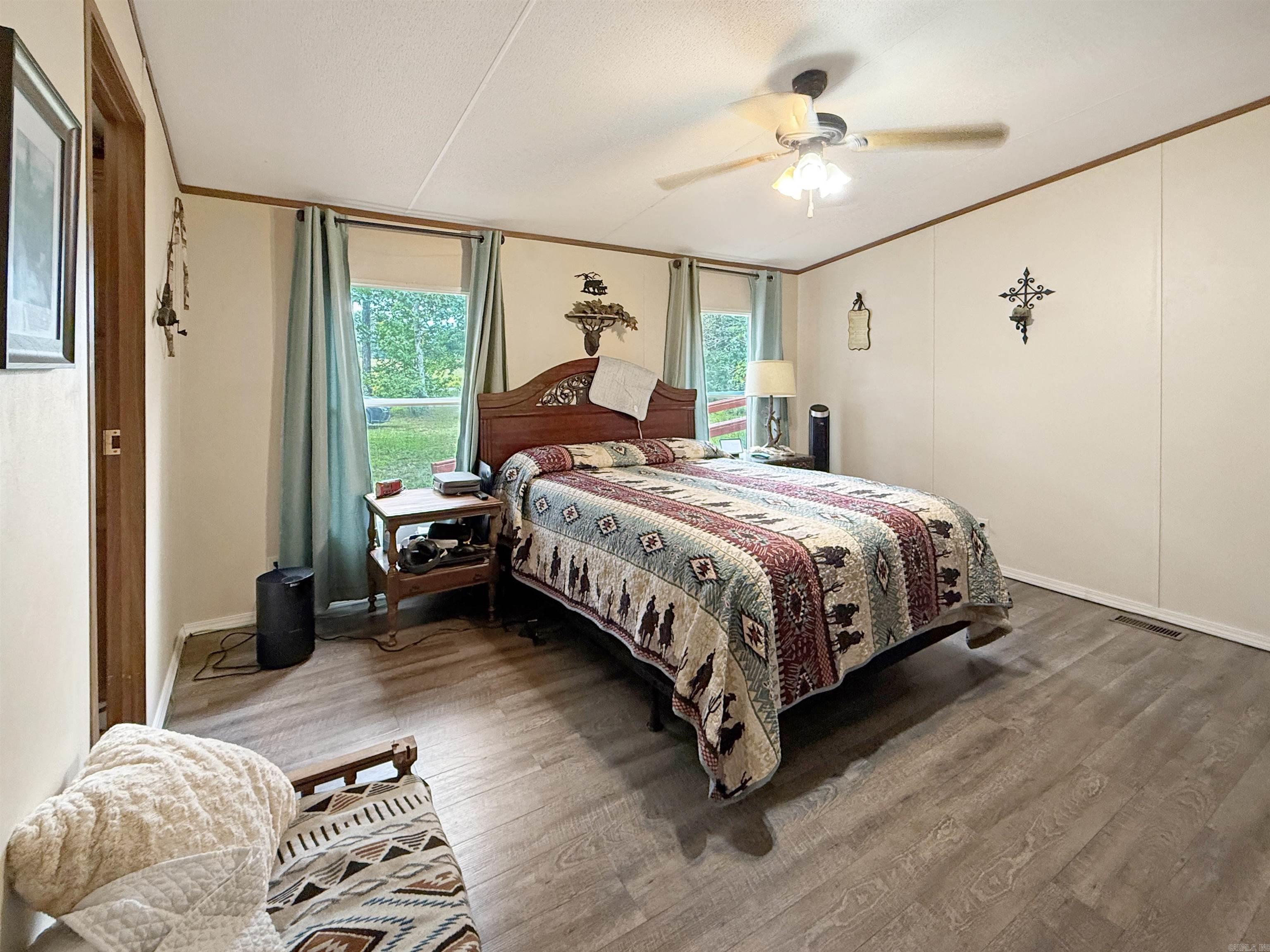 Charming 3BR/2BA manufactured home situated on 0.96 acres, offering the perfect mix of comfort and outdoor living. Enjoy peaceful evenings from the screened-in covered porch or take in breathtaking sunsets from the front porch. Property features a versatile outbuilding and greenhouse, ideal for storage, gardening, or hobbies. With open space and serene views, this home provides both functionality and a welcoming retreat.