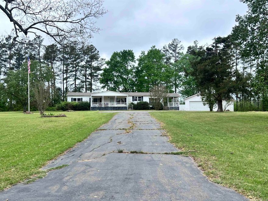 Enjoy peaceful country living in this spacious 3-bedroom, 2-bathroom home situated on 5 beautiful acres just outside the city limits. With over 1,800 square feet of living space, this well-maintained 2001 mobile home offers plenty of room to spread out and relax. Inside, you’ll find a large open floor plan featuring two living areas, perfect for entertaining or creating a separate family or media space. The oversized kitchen provides ample cabinet and counter space and flows seamlessly into both a formal dining area and a breakfast room. The primary suite features an oversized bathroom with a stand-up shower and a separate large soaking tub. Additional highlights include a dedicated laundry room and freshly cleaned carpet throughout. Step outside and take in the wide-open space and beautiful sunset views. The property also includes a storm cellar, a detached garage/storage building, and an additional shop/storage building, offering plenty of room for tools, equipment, or hobbies. If you're looking for privacy, space, and the charm of country living—this property is a must-see! Schedule your showing today! Taxes are after homestead credit.